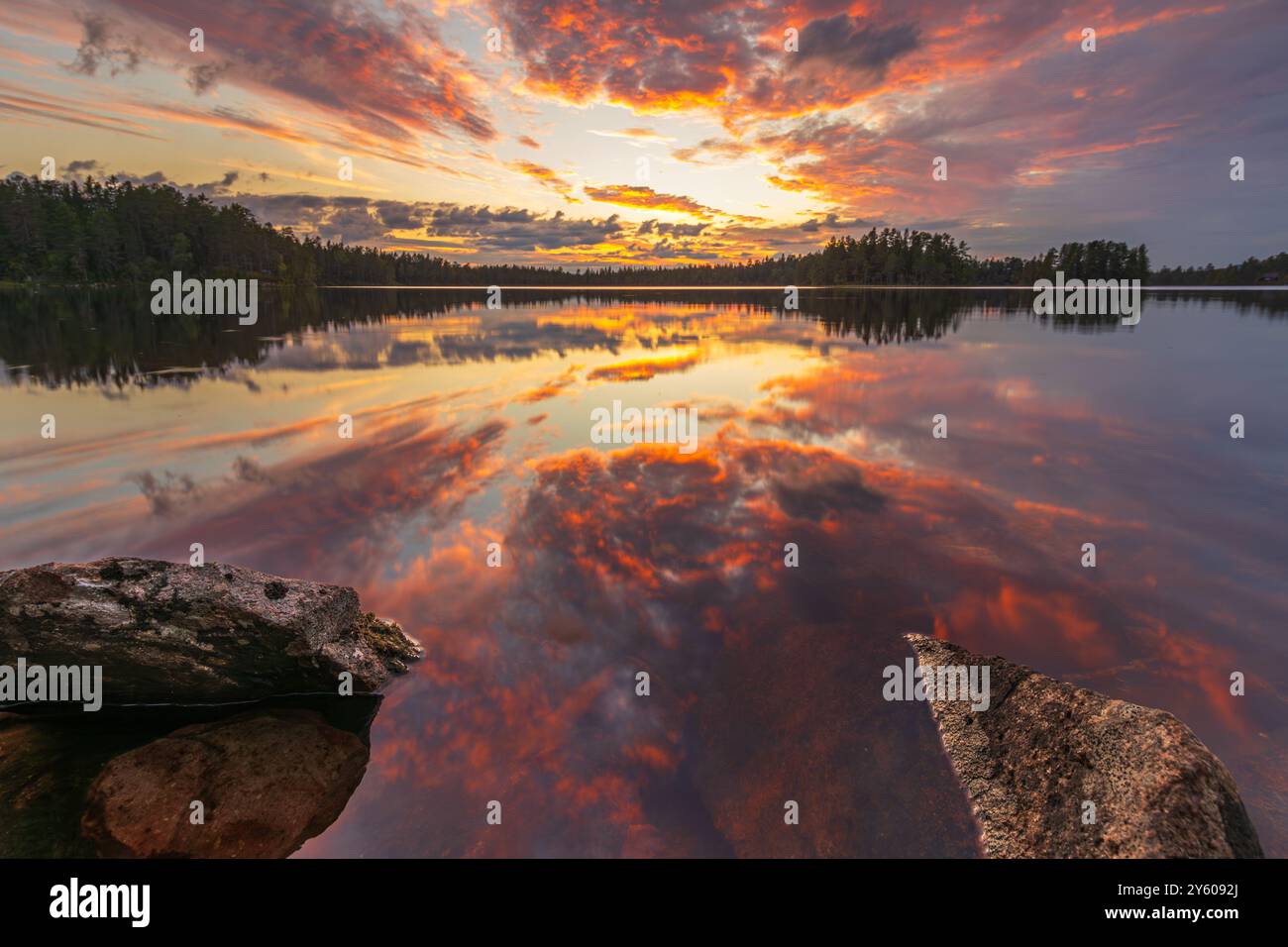 La Svezia è la terra di molti laghi e alberi. Spesso, il vento muore la sera e l'acqua agisce come uno specchio. Quando c'è anche uno spettacolo Foto Stock