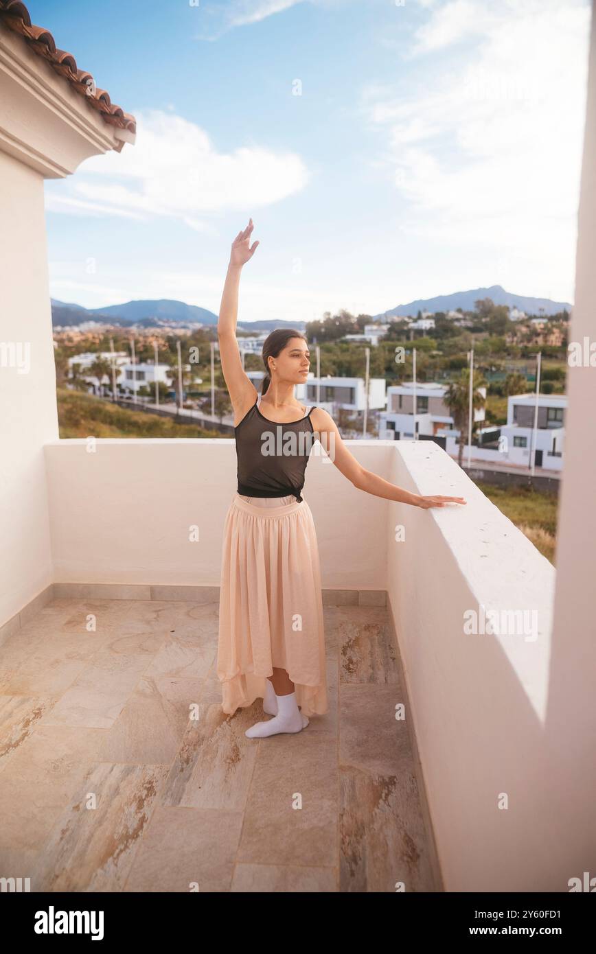 Una posa da balletto straordinariamente elegante scattata splendidamente in un ambiente panoramico con balcone Foto Stock