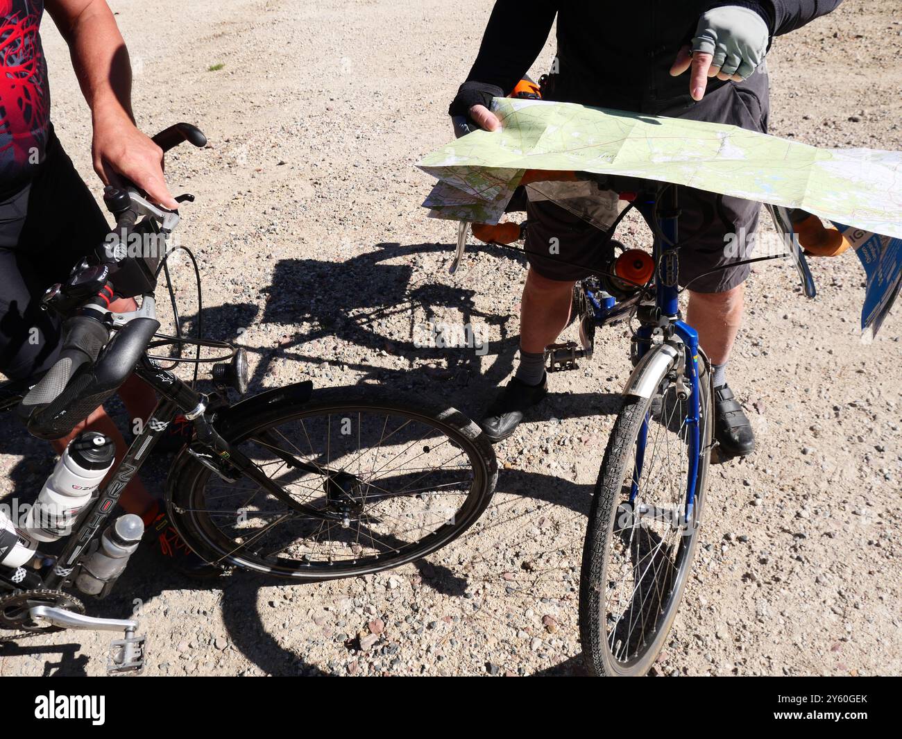 I ciclisti controllano la mappa per la navigazione mentre esplorano percorsi in ghiaia fuoristrada. Chinon, Francia Foto Stock