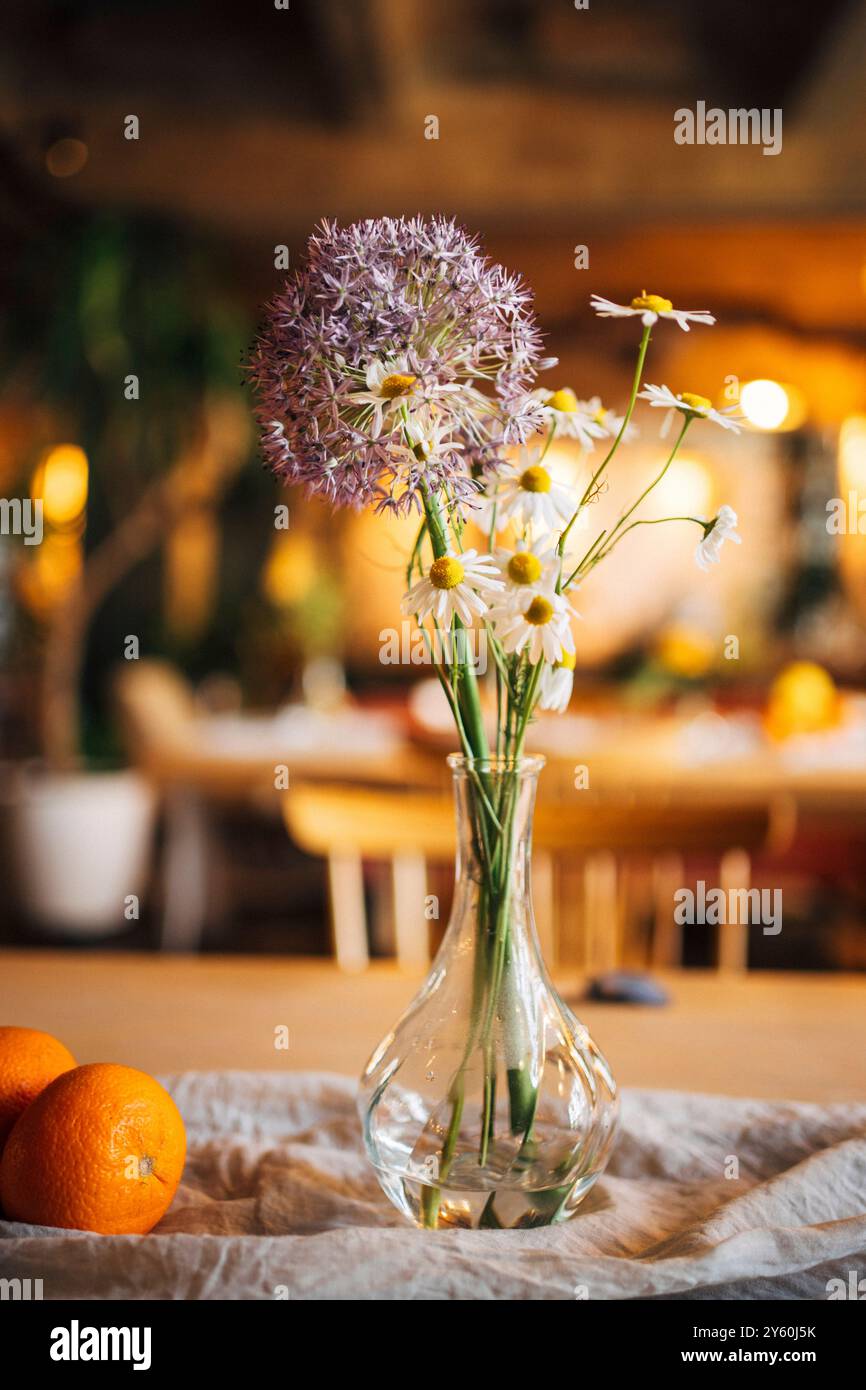 Disposizione floreale minimalista con frutta e lino su un tavolo di legno Foto Stock