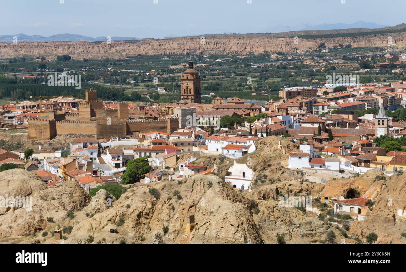 Vista panoramica di una città con edifici storici, chiesa e mura cittadine, circondata da un paesaggio collinare sotto un cielo limpido, Alcazaba, Cattedrale, Cate Foto Stock