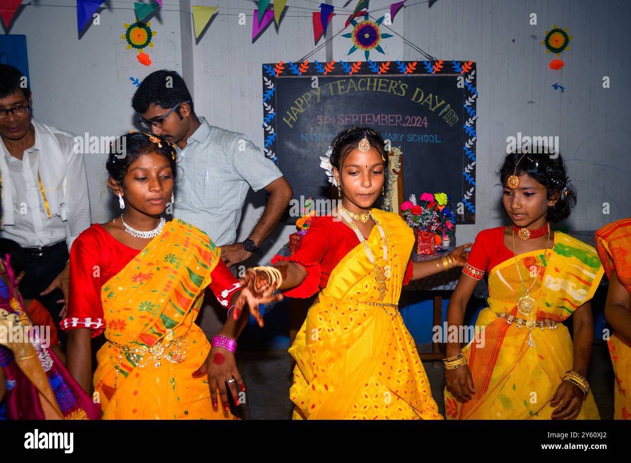 La Nabin Nagar Primary School è una remota scuola rurale situata a Nabin Nagar, lungo il confine tra India e Bangladesh. Nonostante le sfide, la scuola celebra il giorno degli insegnanti il 5 settembre, in occasione del compleanno del Dr. Sarvepalli Radhakrishnan, secondo presidente dell'India. Il preside della scuola prende l'iniziativa di organizzare la celebrazione, preparando ghirlande di fiori di calendula per le sue studentesse prima della loro esibizione di danza. Nabin Nagar, Bengala Occidentale, India. Foto Stock