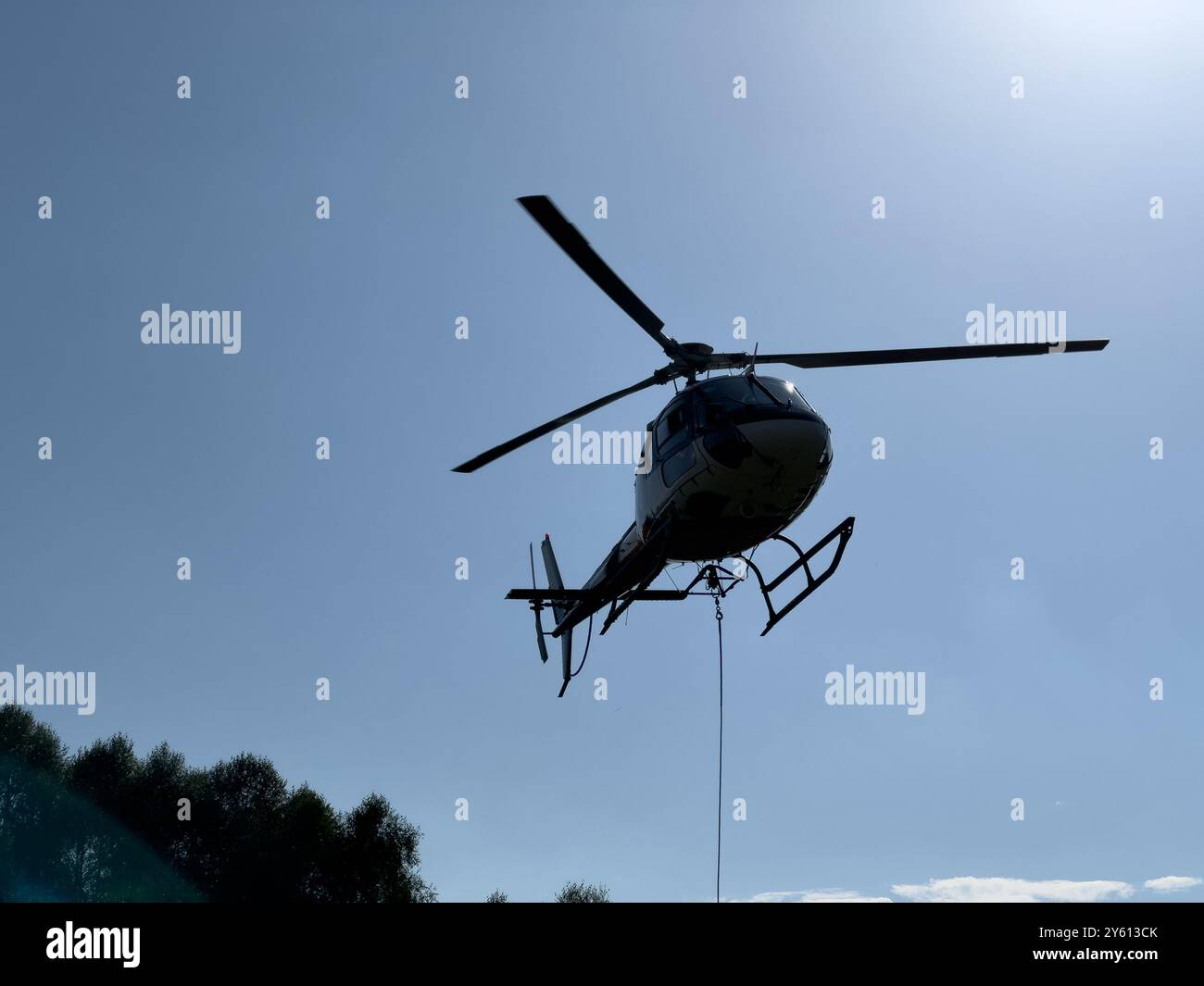 Un elicottero che trasporta un pacchetto sulle montagne del lago di Como, in Italia Foto Stock