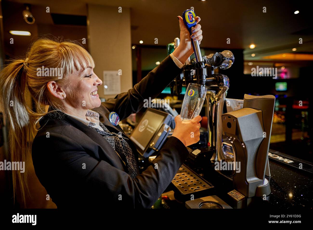 Lady barmaid che serve una pinta Foto Stock