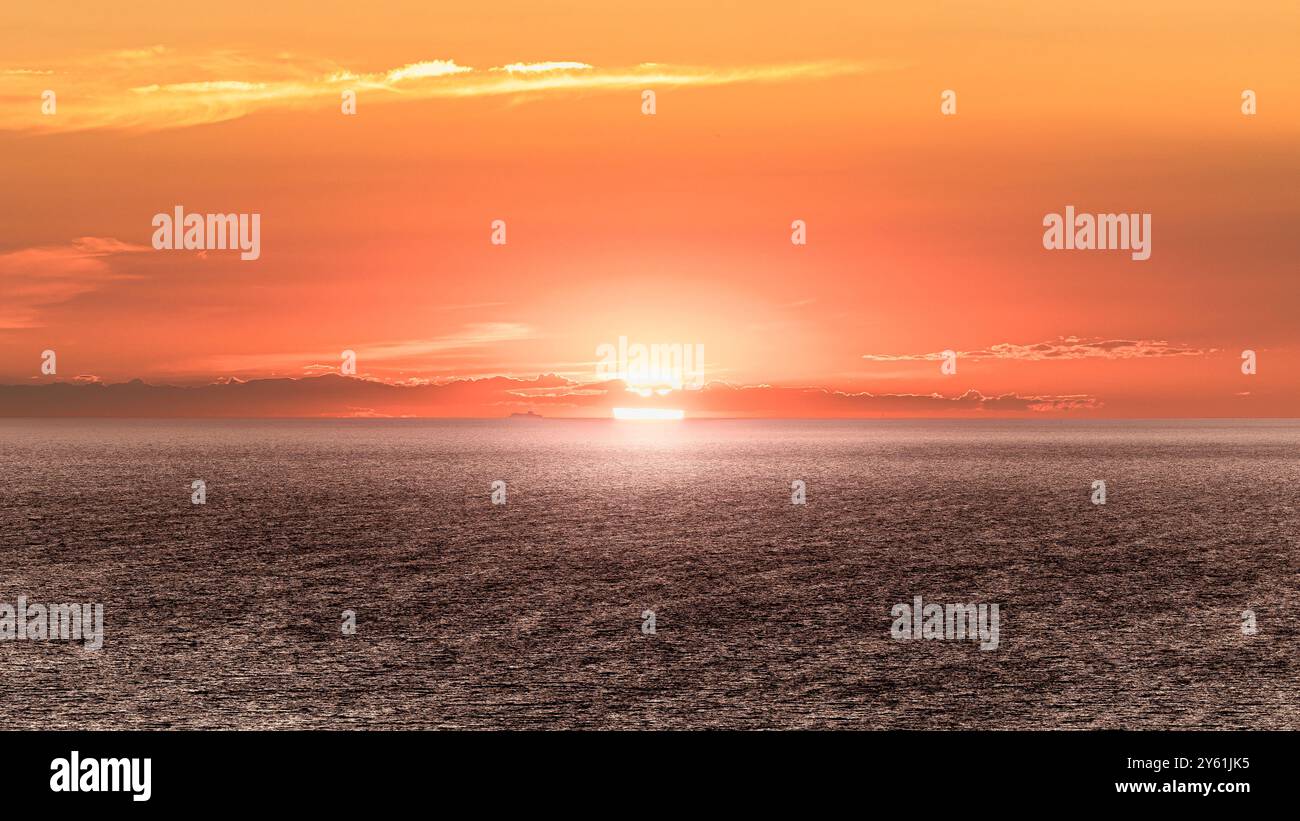 Una lunga pausa al tramonto su una spiaggia mediterranea, il movimento dell'acqua, l'ora d'oro e il paesaggio ispirano tranquillità e pienezza Foto Stock