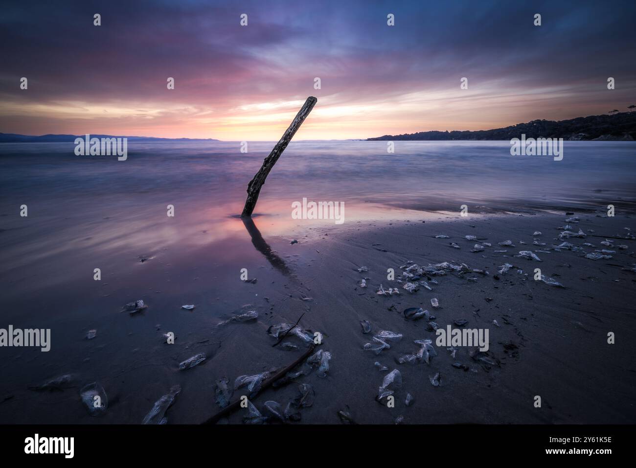 Una lunga pausa al tramonto su una spiaggia mediterranea, il movimento dell'acqua, l'ora d'oro e il paesaggio ispirano tranquillità e pienezza Foto Stock