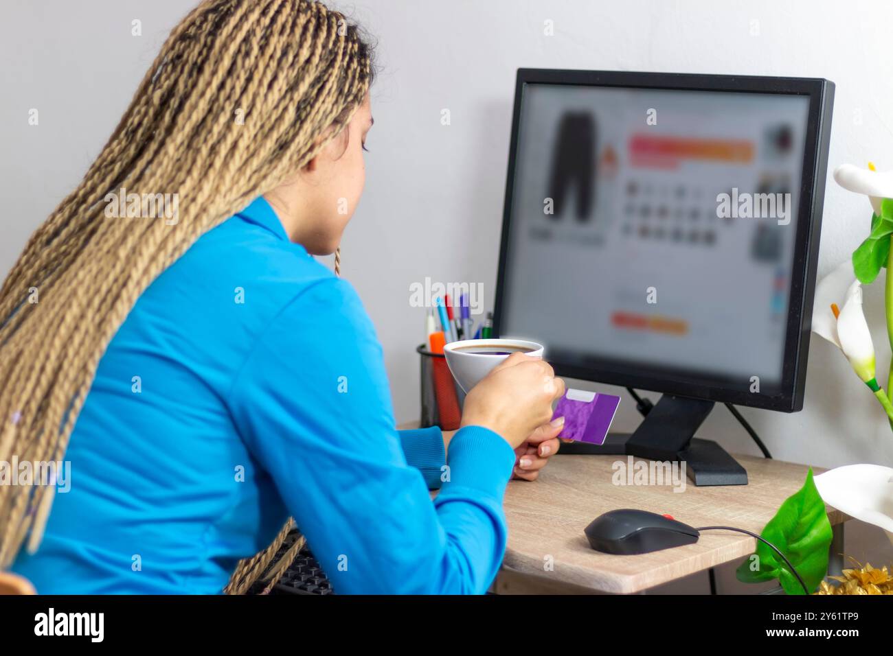 Ragazza adolescente o studentessa che usa il computer e fa shopping online seduto a casa. Tecnologia di pagamento elettronico, stile di vita shopaholic Foto Stock