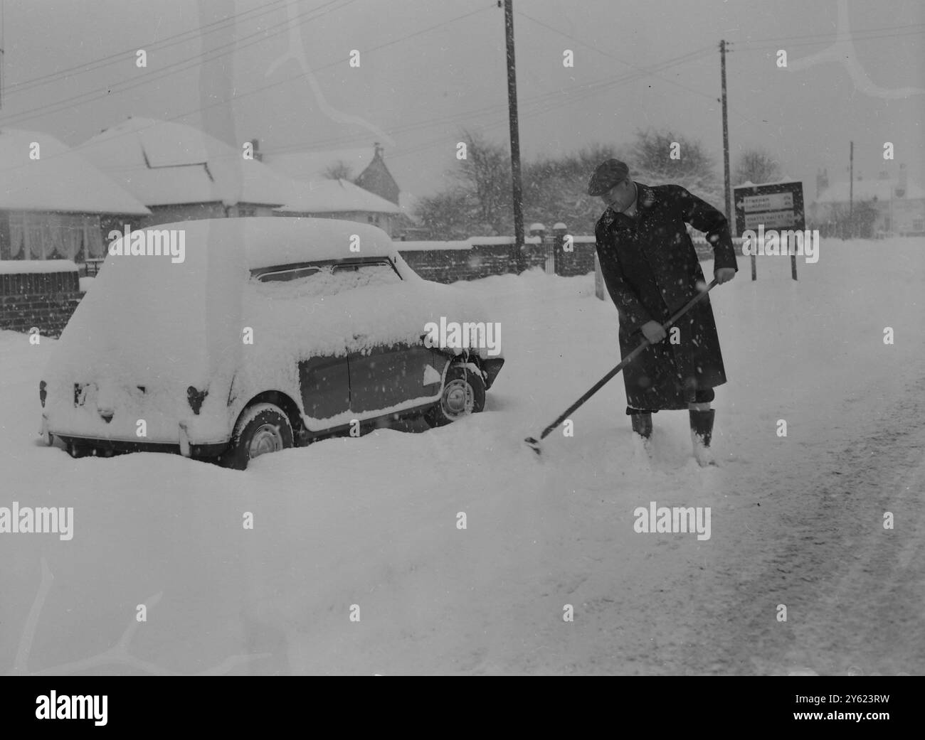 SPIANARE LA STRADA A UN'AUTO COPERTA DI NEVE 10 GENNAIO 1960 Foto Stock