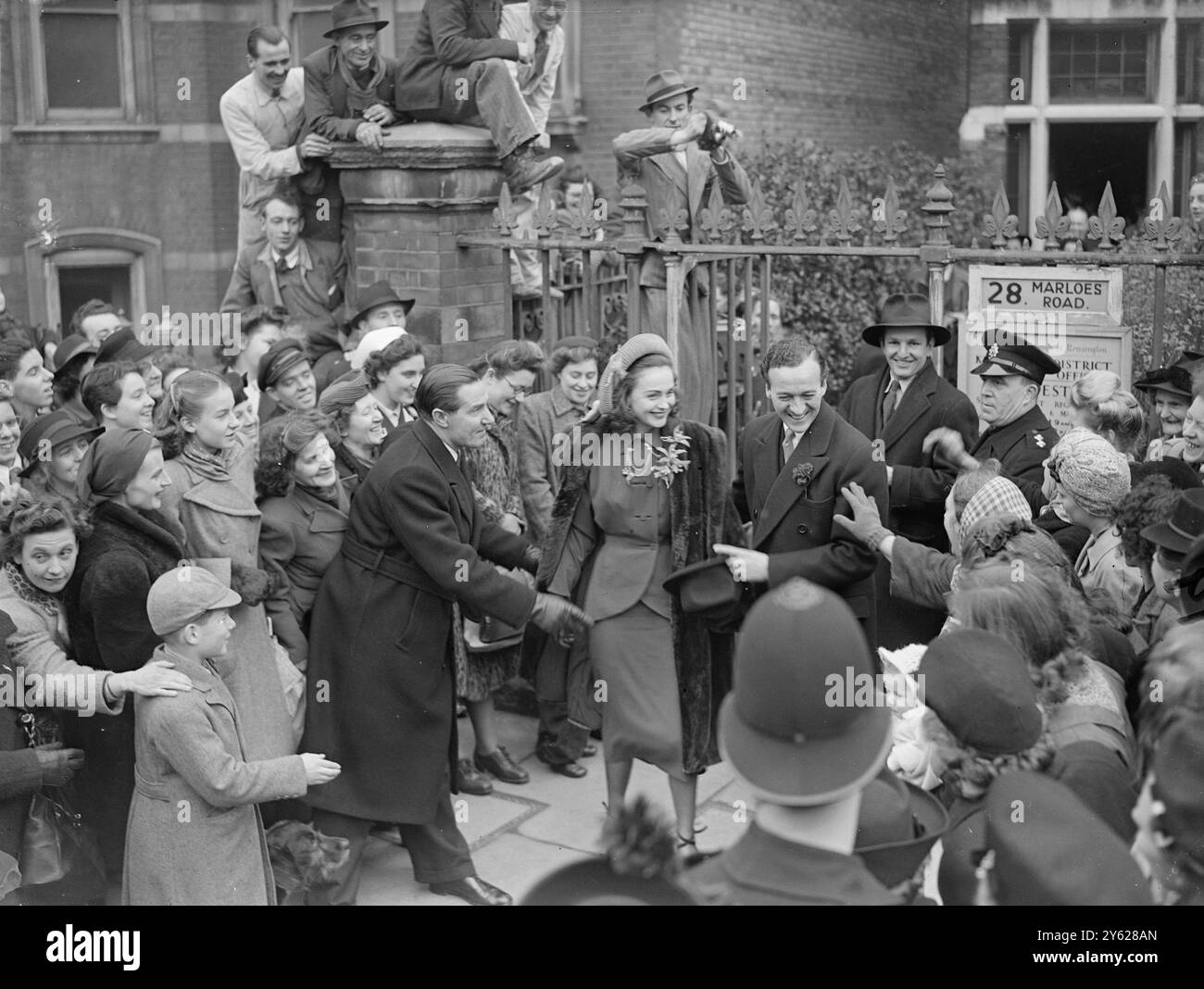 L'attore britannico David Niven e la sua sposa Hjordis Tersmeden di Stoccolma, sono accolti da una grande folla di benestanti mentre lasciano l'ufficio del registro di Kensington dopo il loro matrimonio. La sposa che ha incontrato Mr. Niven durante le riprese di "Bonnie Prince Charlie" di Sir Alexander Korda, in cui interpreta il ruolo del protagonista, è stata in Inghilterra solo sei settimane. 14 gennaio 1948 Foto Stock