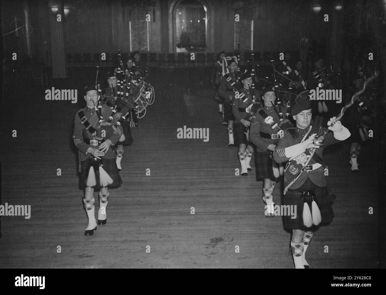 La casa di Grosvenor ha presentato stasera una vista gay mentre gli scozzesi convergevano lì per l'Highland Ball, tenuto in aiuto dell'Airborne Forces Security Fund. L'abbigliamento ufficiale per gli ospiti maschili era o kilt o code, e alle donne fu chiesto di indossare le fasce di tartan. Tre principi erano presenti a questo evento, il primo ballo delle Highland dopo la guerra; il principe Giovanni di Lussemburgo, il principe Roberto d'Austria e il principe Michele di Borbone. Immagini: I membri della Airborne Pipe Band della Highland Division hanno fotografato questa sera al ballo della Grosvner House. 9 gennaio 1948 Foto Stock
