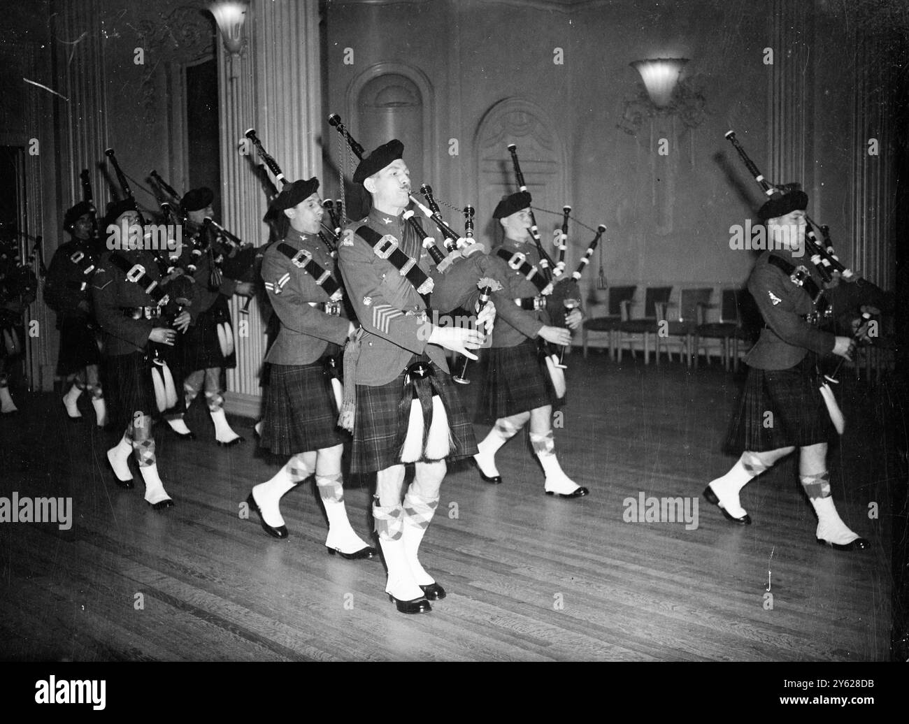 La casa di Grosvenor ha presentato stasera una vista gay mentre gli scozzesi convergevano lì per l'Highland Ball, tenuto in aiuto dell'Airborne Forces Security Fund. L'abbigliamento ufficiale per gli ospiti maschili era o kilt o code, e alle donne fu chiesto di indossare le fasce di tartan. Tre principi erano presenti a questo evento, il primo ballo delle Highland dopo la guerra; il principe Giovanni di Lussemburgo, il principe Roberto d'Austria e il principe Michele di Borbone. Immagini: I membri della Airborne Pipe Band della Highland Division hanno fotografato questa sera al ballo della Grosvner House. 9 gennaio 1948 Foto Stock