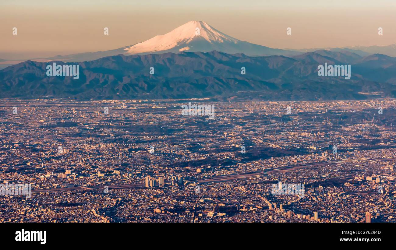Vista aerea dell'area metropolitana di Tokyo e del Monte Fuji innevato all'alba Foto Stock