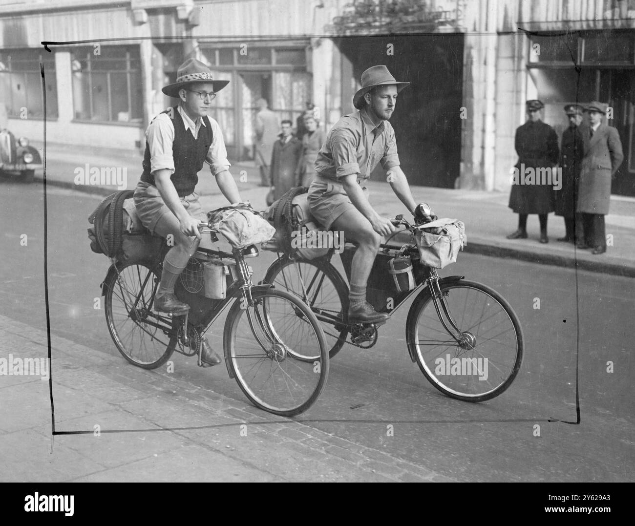 Geoffrey Cauldwell, 22 anni, e suo fratello Harry, 21 anni, di Bulawayo, Rhodesia meridionale (Zimbabwe) che hanno in programma di girare il mondo in 1.000 giorni, sono arrivati oggi alla Raleigh Industries Fair di Londra. Con una media di 75 miglia al giorno, Cauldwell ha attraversato l'Africa sudorientale, il Kenya, il Sudan, l'Egitto e la Francia, coprendo le paludi, montagna e giungla. Sono a Londra, stanno progettando la scena americana del loro viaggio. Immagini: Harry e Geoffrey spingono i pedali nella seconda fase del loro viaggio a Londra oggi. 25 novembre 1947 Foto Stock