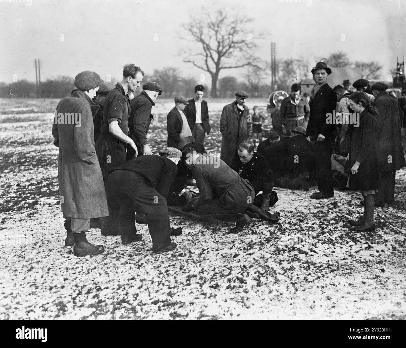 Un'avventura di Capodanno sul ghiaccio coperto Brickyard Pond al Bentley Toll Bar, vicino a Doncaster, ha portato alla morte il bambino di otto anni Brian Aitcheson, di Ainthorpe-Road, Adwick, e il suo amico, Denis McCarthy, di Adwick-Lane. I vigili del fuoco locali, subito sul posto dopo che l'allarme è stato lanciato, hanno legato al loro motore antincendio una corda che era tenuta sul lato opposto dello stagno da 20 uomini. Poi, con una linea di sicurezza intorno alla sua vita, l'ufficiale della compagnia Plane, delle N.F.S., ha iniziato un pericoloso viaggio a mani nude lungo la corda per afferrare e portare a terra uno dei ragazzi. Uno sforzo simile per Section Lead Foto Stock