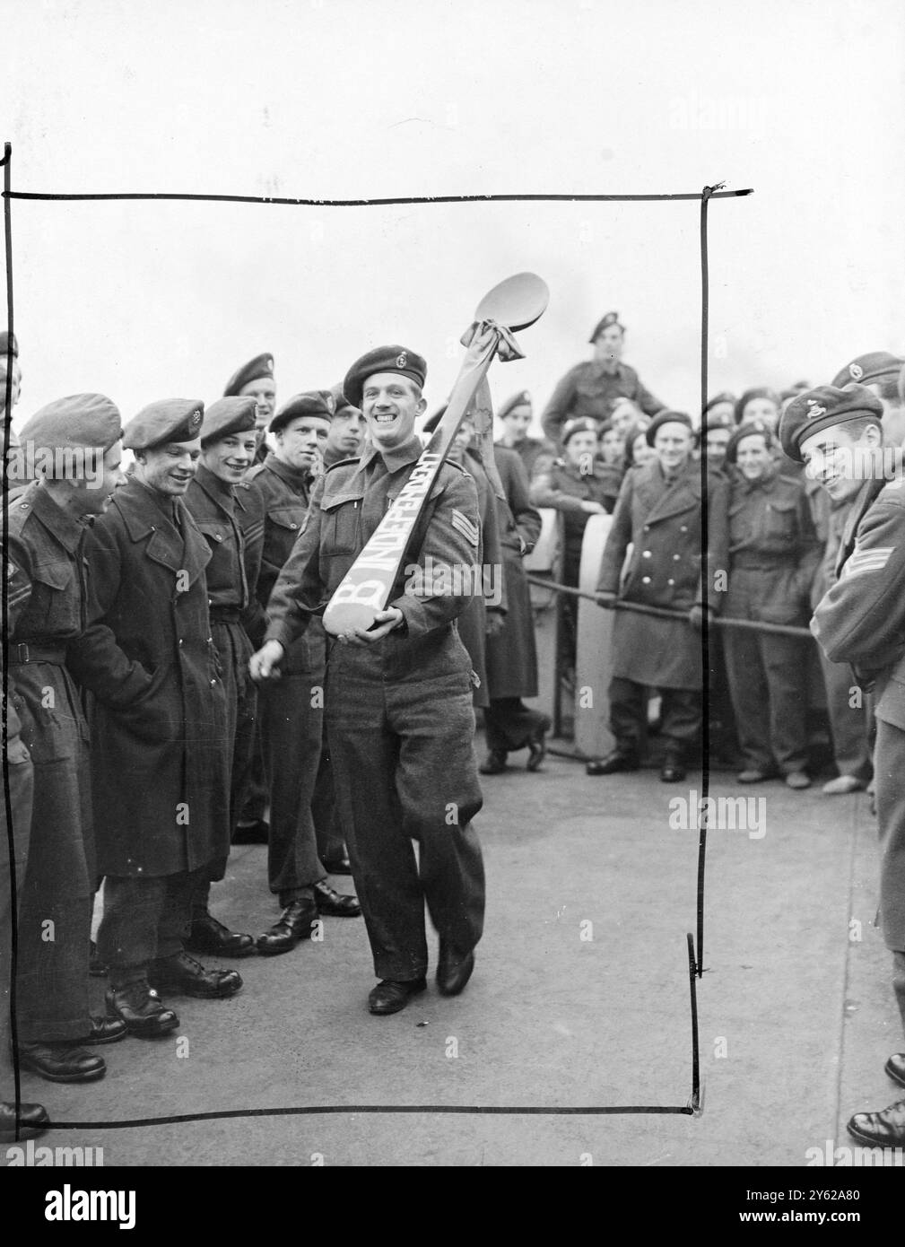 Gli uomini del 2° Battaglione, il reggimento Essex, sono arrivati a Southampton dall'Italia oggi nella SS Taos Victory. Le ultime truppe britanniche a lasciare il suolo italiano dopo circa 4 anni di combattimenti e di occupazione, a partire dagli sbarchi siciliani, saranno tutte a casa in tempo per Natale. Ora solo le tombe di 42.000 soldati britannici nel 41 o cimiteri in tutte le parti d'Italia rimangono per commemorare la parte della Gran Bretagna nella liberazione del paese. L'immagine mostra: "Hanno portato il cucchiaio di legno". Sgt T.E. Peggie, Royal Signals, di Ayr Scozia, porta a terra oggi a Southampton. La mascotte di 1 Foto Stock