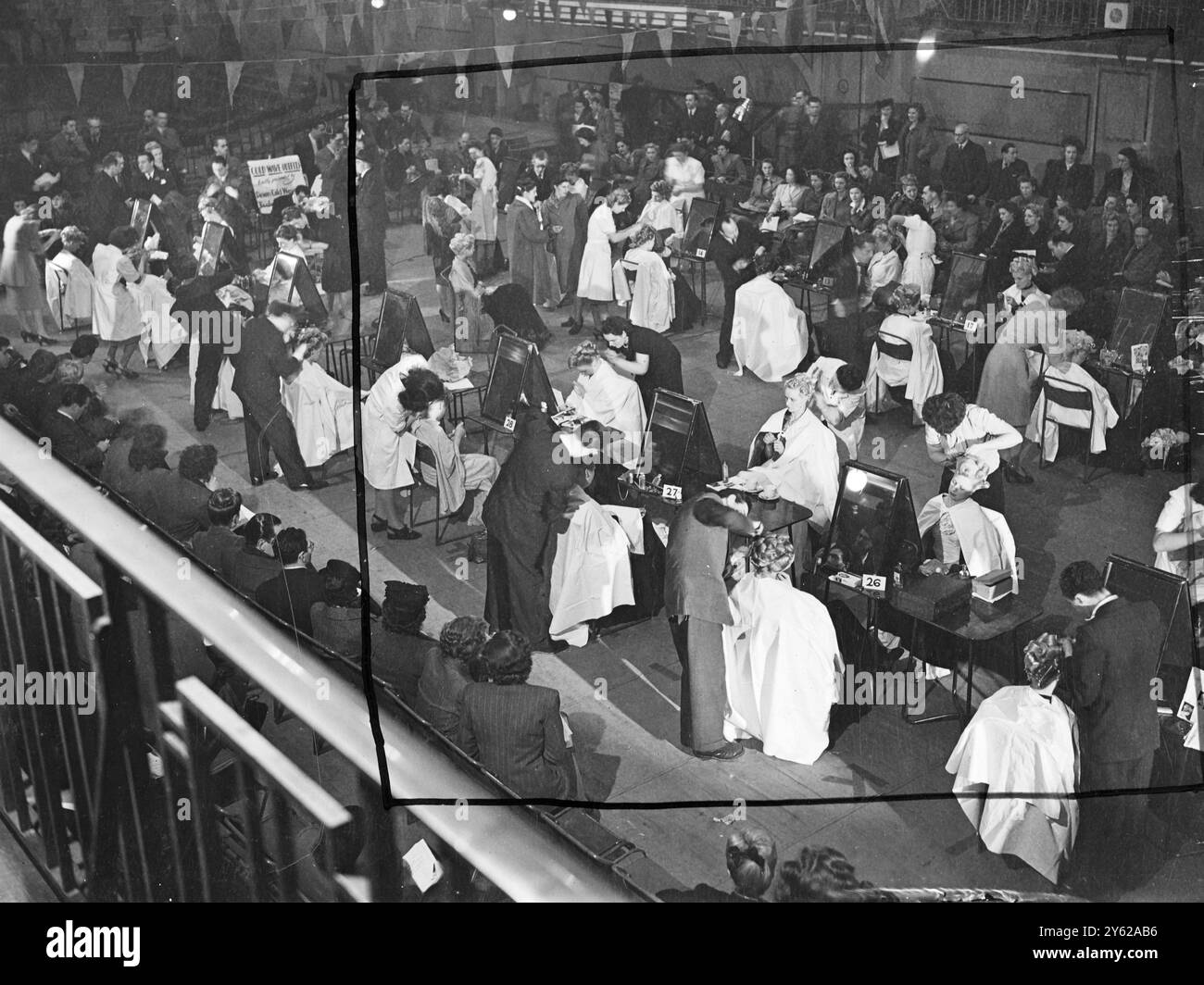 I parrucchieri britannici hanno avuto un'intensa domenica libera oggi, quando si sono riuniti alla Seymour Hall e Marylebone per competere per il Silver Rose Bowl Contest, organizzato dalla Fellowship of Hair Artists of Great Britain. In un concorso aperto solo ai partecipanti britannici, è stato utilizzato uno stile set - la moda Fellowship Winter per il 1948. Immagini: Una visione generale della scena mentre i concorrenti preparano i loro modelli per i giudici della Seymour Hall. 7 dicembre 1947 Foto Stock