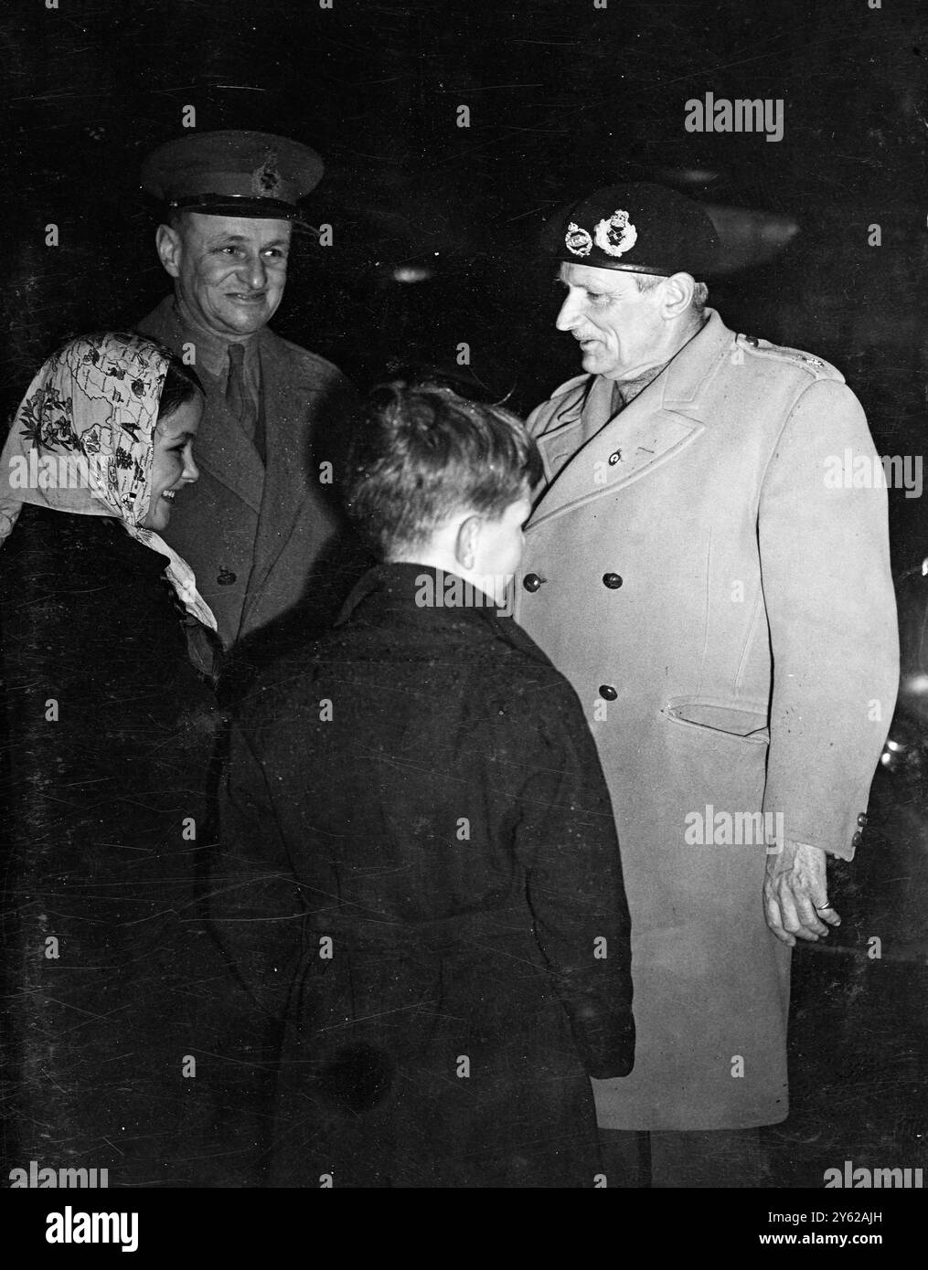 Dopo aver percorso 20.000 miglia e visitato ogni colonia dell'Africa Britannica, il feldmaresciallo Lord Montgomery, Capo di Stato maggiore Imperiale, sbarcò oggi con il suo aereo York all'aeroporto di Northolt. Abbronzata al sole e con il distintivo della Legione sudafricana, "Monty" è stato accolto dal tenente generale Simpson Vice - C.I.G.S. Picture Shows: Lord Montgomery è accolto da Sir Eric B.B. Speed, Sottosegretario permanente di Stato per la Guerra, e dai suoi due figli all'aeroporto oggi. Il nuovo distintivo di "Monty" è nel risvolto del suo caldo cappotto britannico. 18 dicembre 1947 Foto Stock