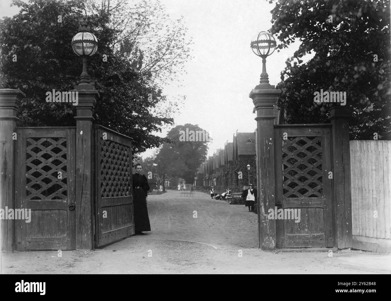 ARCHIVIO BOX 6 ARC 0184 D 236 RIFERIMENTO: 001483 CASA DEL VILLAGGIO DELLE RAGAZZE: CANCELLI D'INGRESSO DATA : C 1895 VEDUTA DEL PAESE CHE GUARDA ATTRAVERSO IL CANCELLO D'INGRESSO Foto Stock