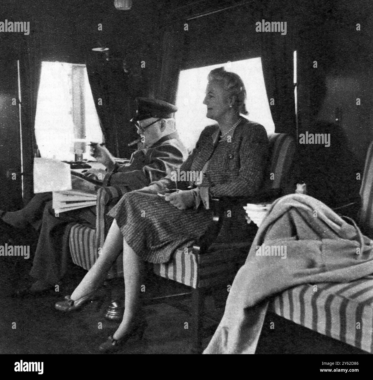 Sul treno speciale del primo Ministro durante il viaggio in Canada e negli Stati Uniti : Mr. Churchill che legge dispacci, con la signora Churchill. Per il suo viaggio in Canada e negli Stati Uniti d'America il primo ministro ha utilizzato un treno speciale che lui e i suoi segretari sono stati in grado di lavorare durante il viaggio. Questo eccellente studio del nostro grande primo Ministro e di sua moglie gli mostra - inevitabile sigaro in bocca leggendo importanti dispacci. 2 ottobre 1943 Foto Stock