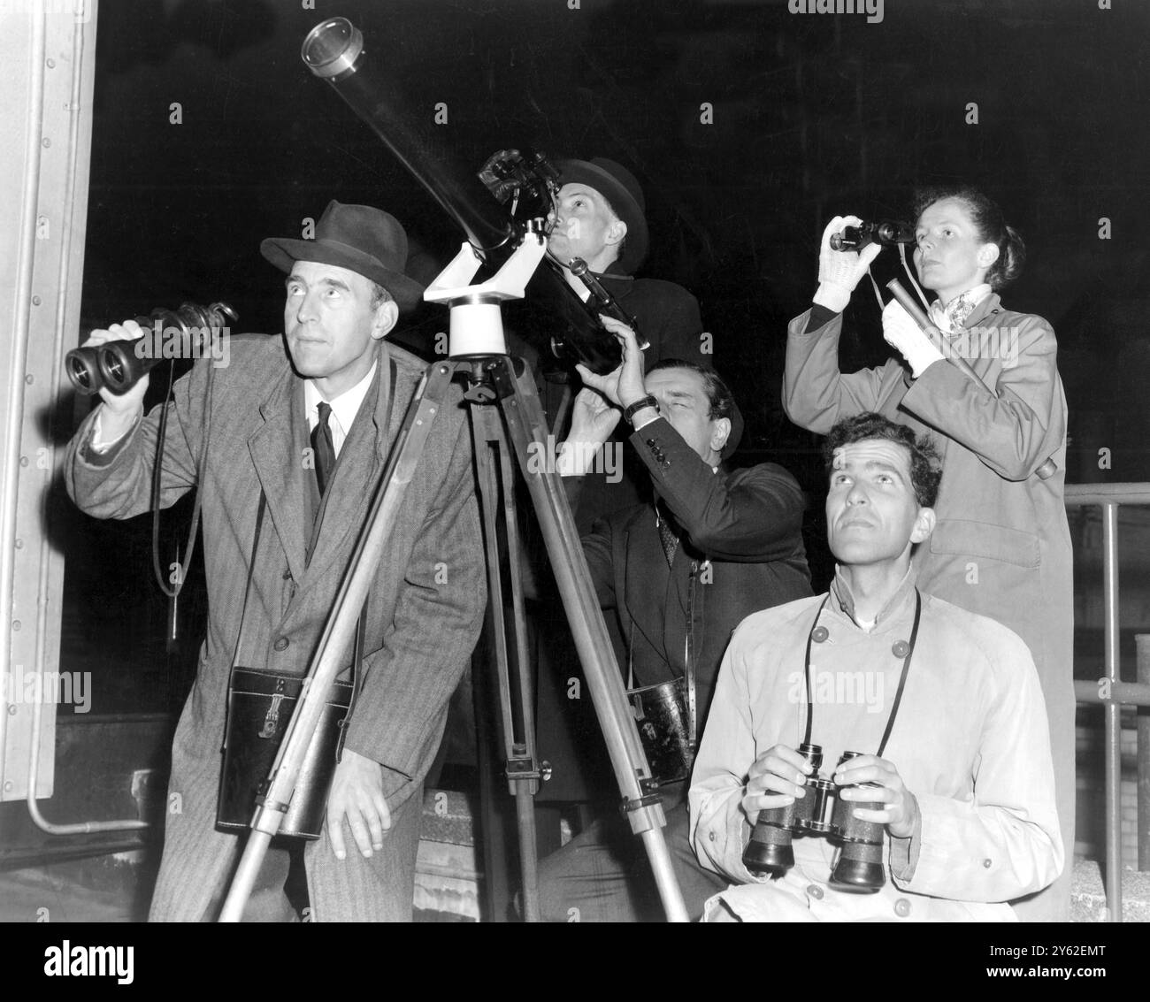 I londinesi guardano il satellite terrestre russo il 5 ottobre 1957. Anche se il satellite è più di 560 miglia e non è più grande di un pallone da calcio, gli scienziati dicono che con l'aiuto di un binocolo o di un telescopio può essere visto. Questi londinesi sono ansiosamente in attesa di vedere se riescono a individuare la "luna fatta dall'uomo". Foto Stock