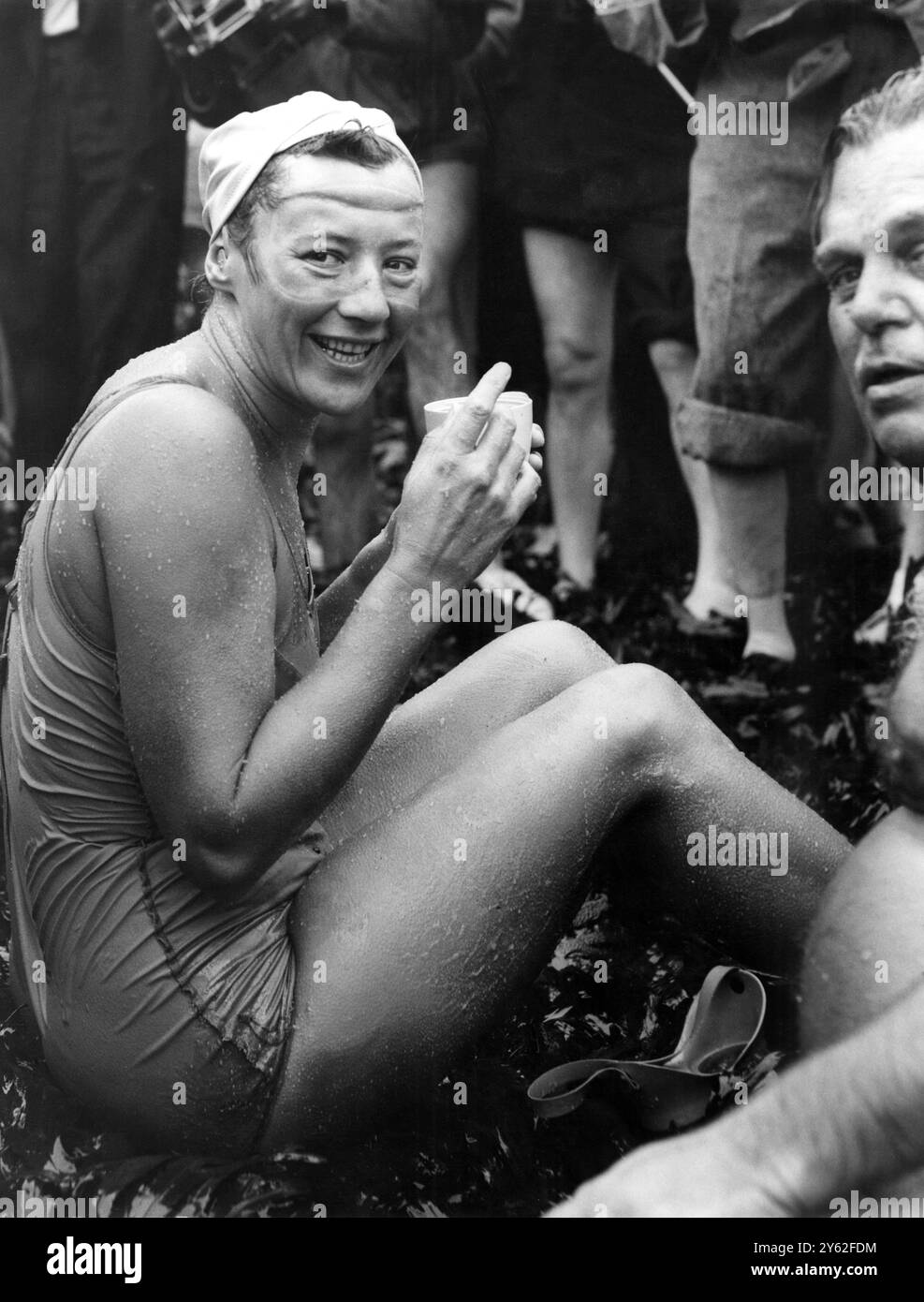 Greta Andersen, 31 anni di età danese americana, si trova a riva vicino a dover dopo aver vinto la gara internazionale di nuoto Butlin cross-Chanel per il secondo anno consecutivo. Il suo tempo di 11 ore e' un record per una donna. 23 agosto 1958 primo piano a destra è il signor Billy Butlin, organizzatore della gara che l'aveva accompagnata nelle ultime 40 iarde della sua nuotata. Foto Stock