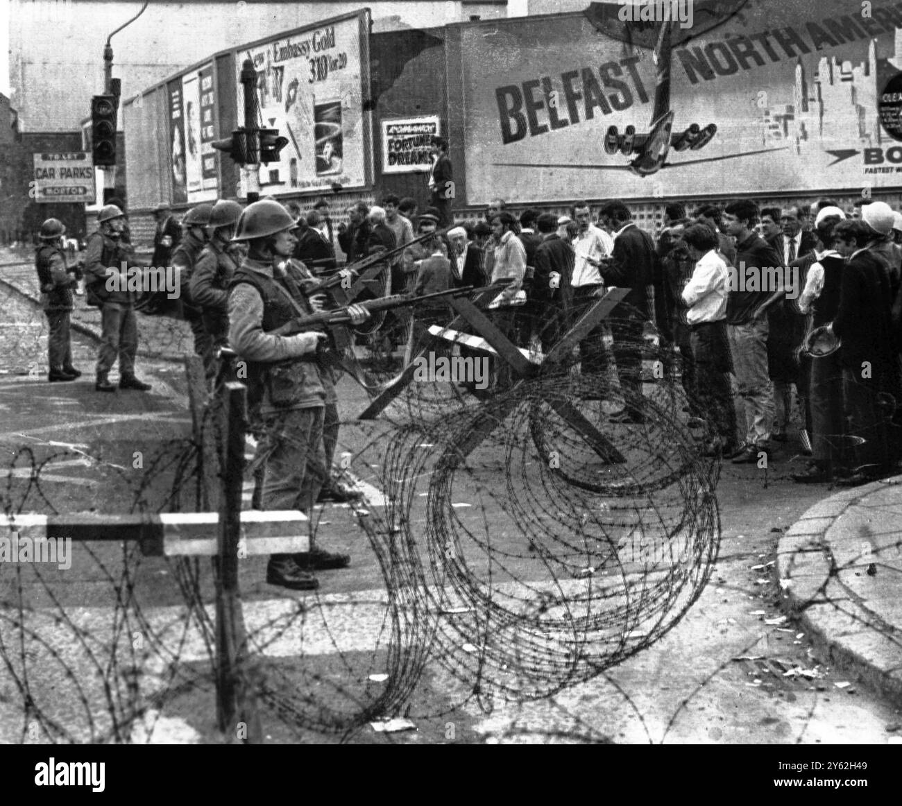 Belfast . Irlanda del Nord . La scena nella zona di Catholic Falls Road, o Belfast devastata dalla rivolta, si è scontrata faccia a faccia con le truppe britanniche armate con elmetto d'acciaio e una barricata di filo spinato che le separava. Le truppe britanniche marciarono nella città e gettarono le barricate nel tentativo di separare le fazioni cattoliche e protestanti militanti il 15 agosto 1969 Foto Stock