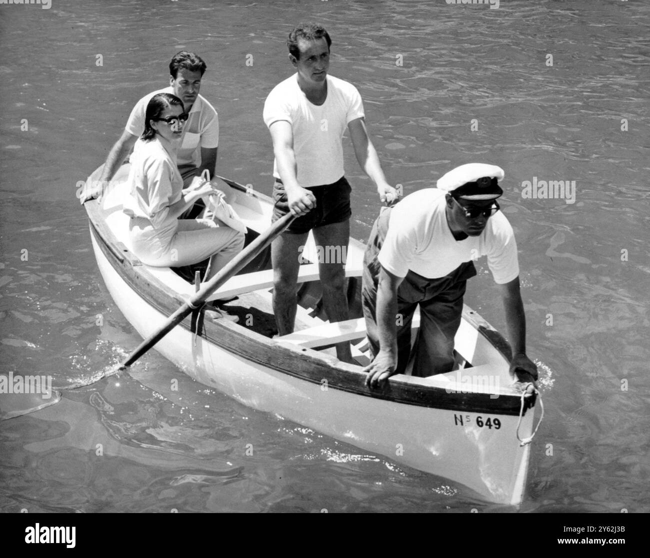 Maximillian Schell e la compagna Principessa Soraya. Entrambi i passeggeri si spostano in barca, arrivando sulla spiaggia durante un tour di Capri, Italia, il 4 luglio 1964 Foto Stock