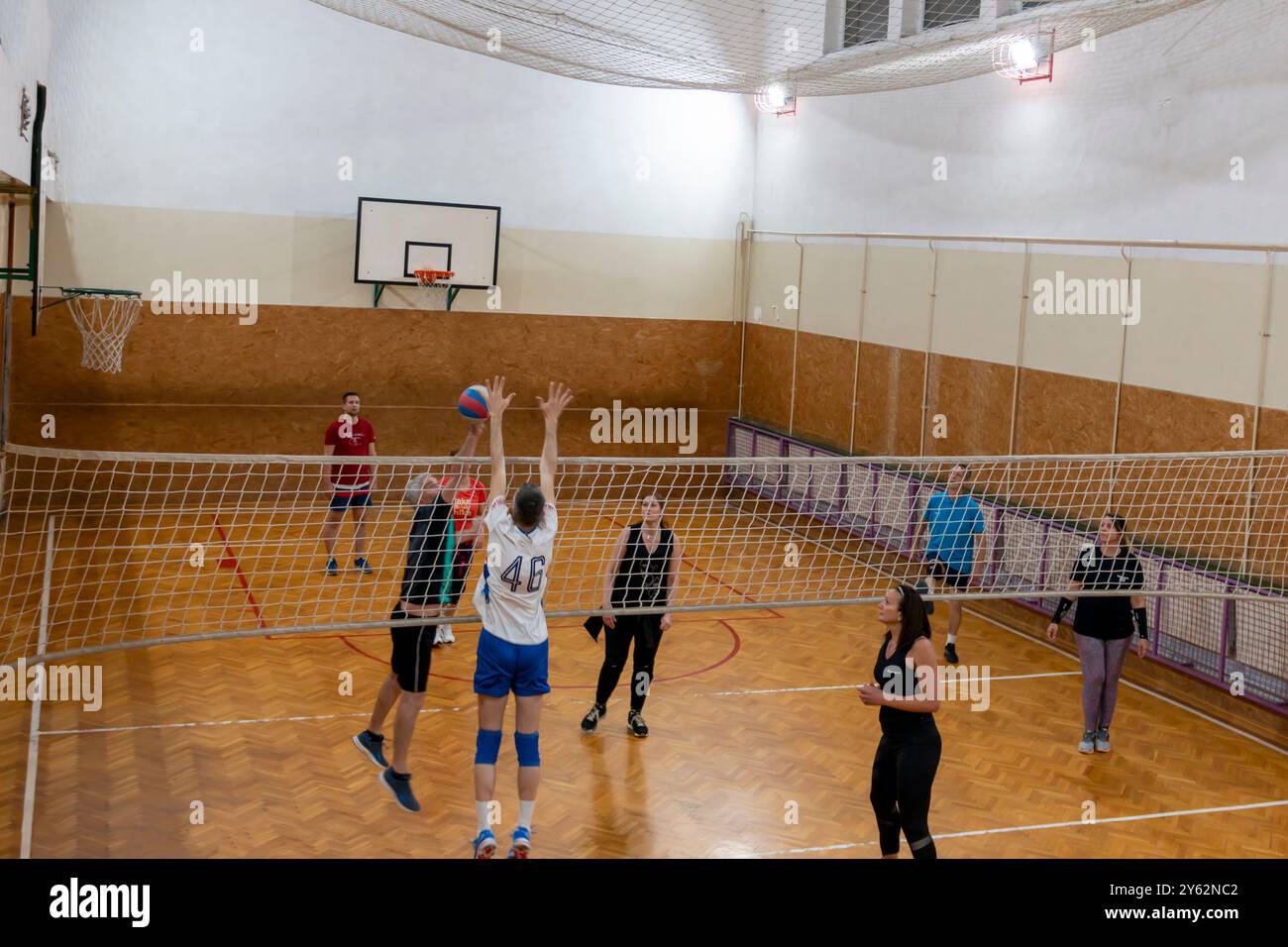 Giocatori dilettanti di pallavolo che saltano in piedi in posizione difensiva sul campo coperto. Pallavolo con squadre di uomini, donne e co-ed. B Foto Stock