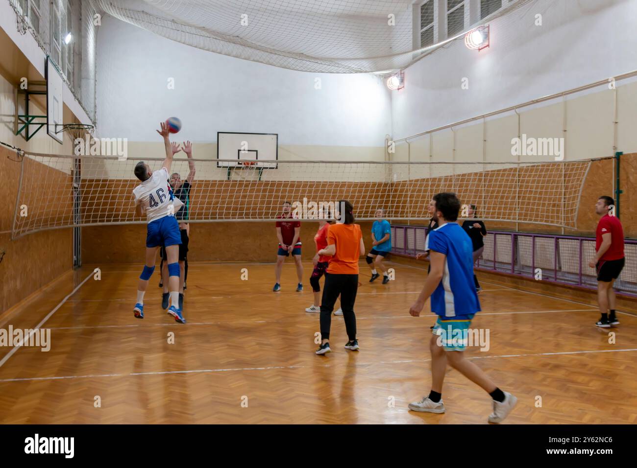 Giocatori dilettanti di pallavolo che saltano in piedi in posizione difensiva sul campo coperto. Pallavolo con squadre di uomini, donne e co-ed. B Foto Stock