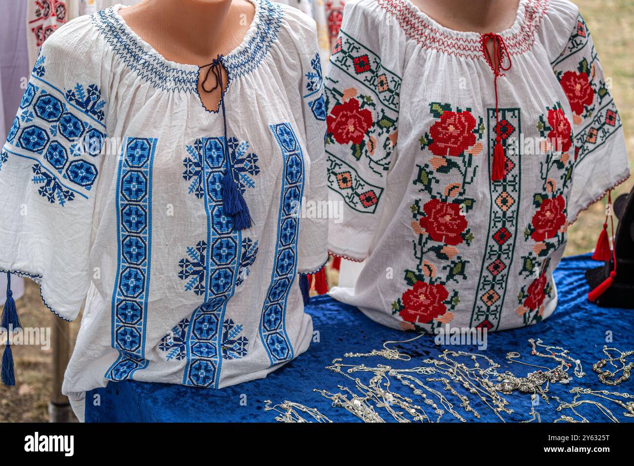 Vecchi costumi tradizionali rumeni con ricami, specifici per le donne (in rumeno sono chiamati II) esposti in vendita in una fiera tradizionale. Foto Stock