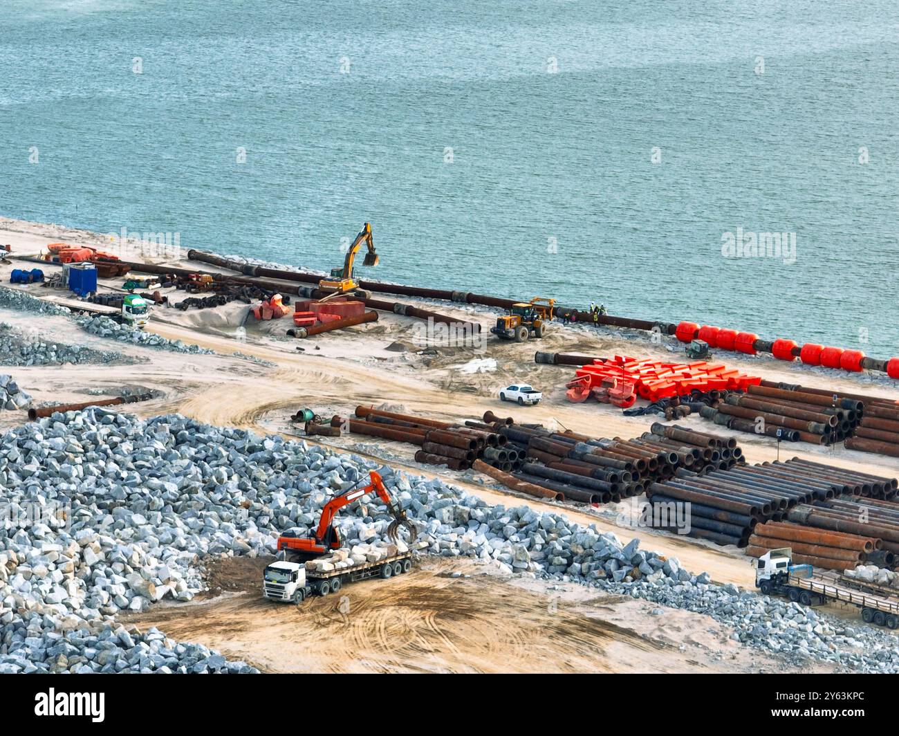 Vista aerea del cantiere di bonifica del terreno per un nuovo terminal portuale. Espansione del commercio globale, efficienza nella movimentazione dei carichi e ambiente Foto Stock