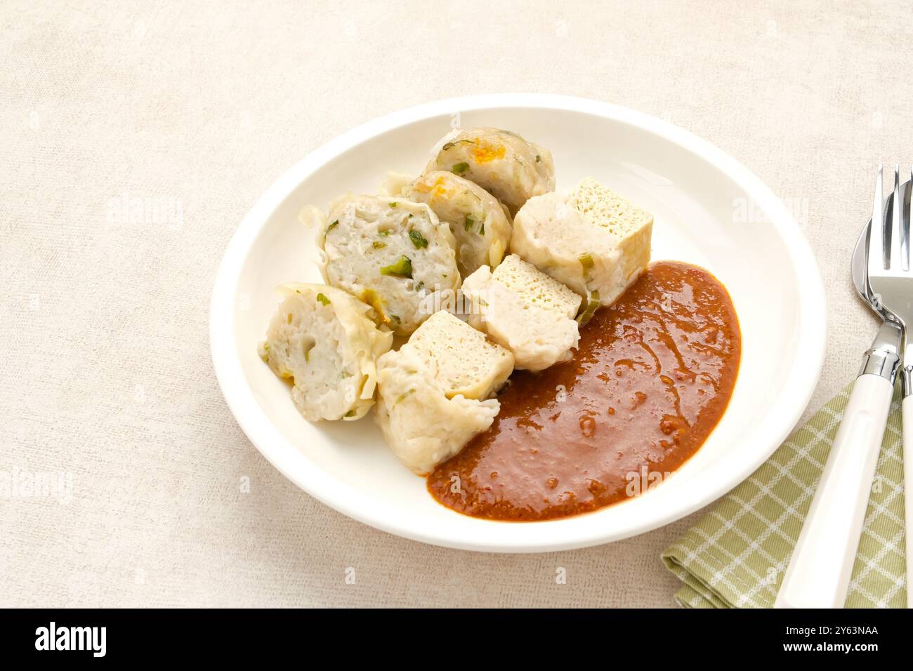 Batagor, a base di gnocchi di pesce o pollo, tofu, farina di tapioca servita con salsa di arachidi. Cibo indonesiano Foto Stock