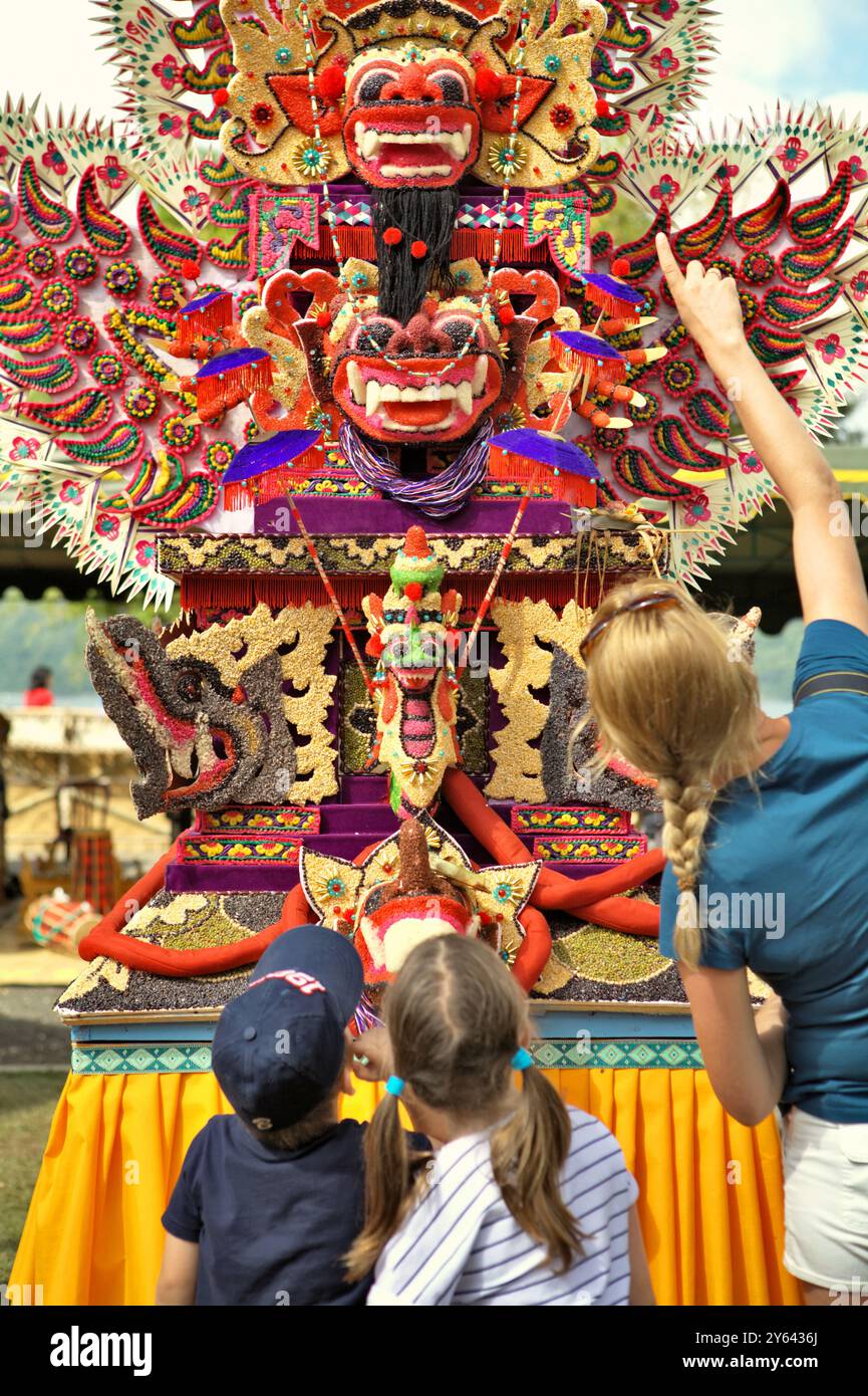 Donne e bambini turisti che prestano attenzione a un'arte scultorea tradizionale fatta di farina di riso (offerta per cerimonia spirituale) a Bali, Indonesia. Foto Stock