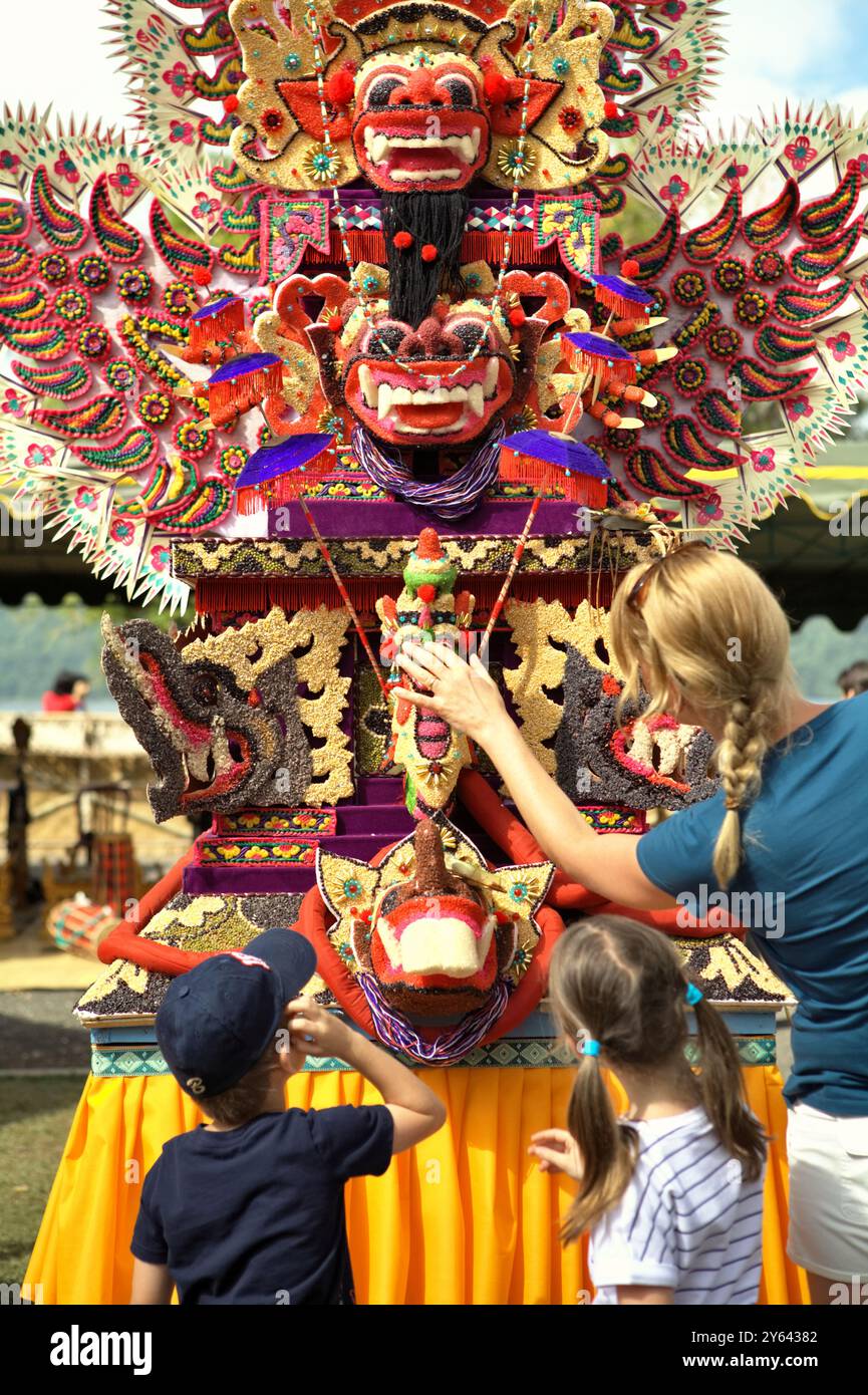 Donne e bambini turisti che prestano attenzione a un'arte scultorea tradizionale fatta di farina di riso (offerta per cerimonia spirituale) a Bali, Indonesia. Foto Stock