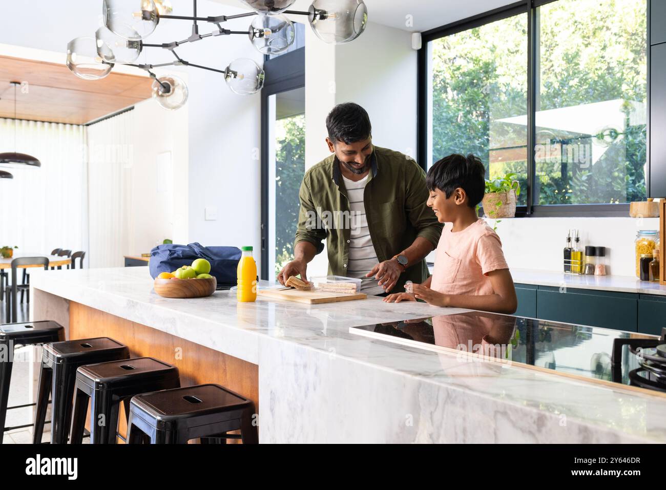 padre e figlio indiani preparano la colazione insieme in una cucina moderna, tempo di legame Foto Stock