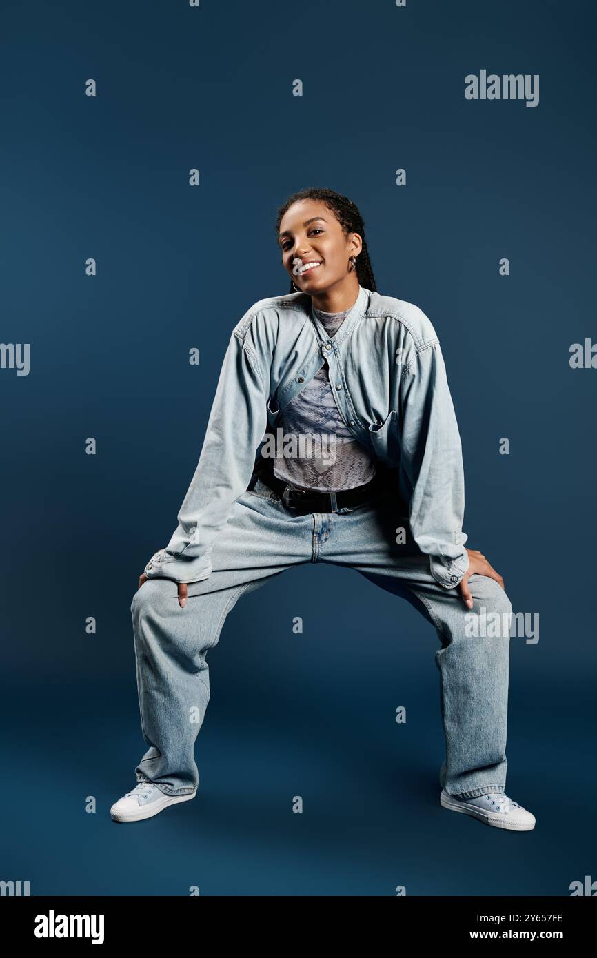 Una giovane donna sicura di sé mette in mostra il suo stile e personalità unici in un abbigliamento alla moda. Foto Stock