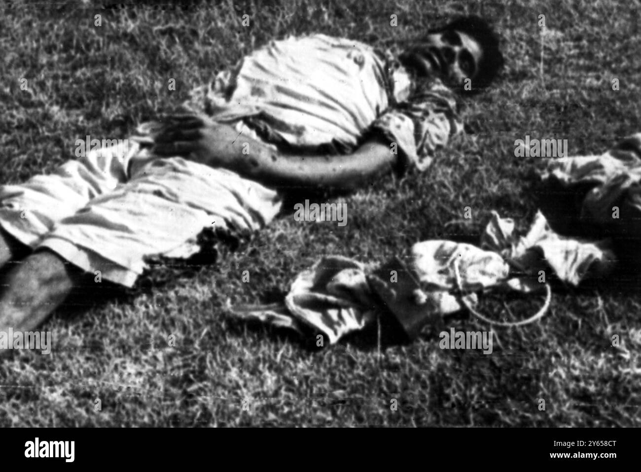 Questa foto ufficiale del governo indiano mostra un presunto infiltrato pakistano sparato da una pattuglia dell' esercito indiano nel settore Mendhar , vicino a Jammu , Kashmir , l' 8 agosto . La foto mostra anche una bomba a orologeria con kit detonatore che si dice che l'uomo morto stesse trasportando . Ieri sera l' India ha affermato che 84 infiltrati pakistani sono stati uccisi nella linea del cessate il fuoco del Kashmir negli ultimi giorni . Le perdite indiane furono 29 morti e 27 feriti . 12 agosto 1965 Foto Stock