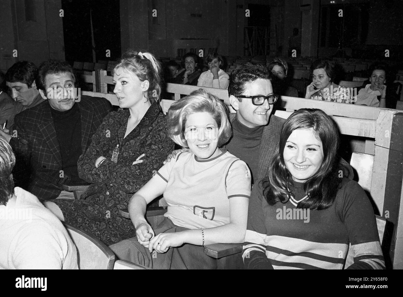 Un quintetto di cantanti pop si rilassa durante una pausa nelle prove per il Festival della canzone di San Remo del 1967. I cantanti sono, da sinistra, l'italiano Domenico Modugno, vincitore di due festival, Anna German di Polands, Donatella Moretti d'Italia, che siede sul grembo di Jimmy Fontana e le ragazze descritte come la "rivelazione" di quest'anno Roberta Amadeu. 26 gennaio 1967 Foto Stock