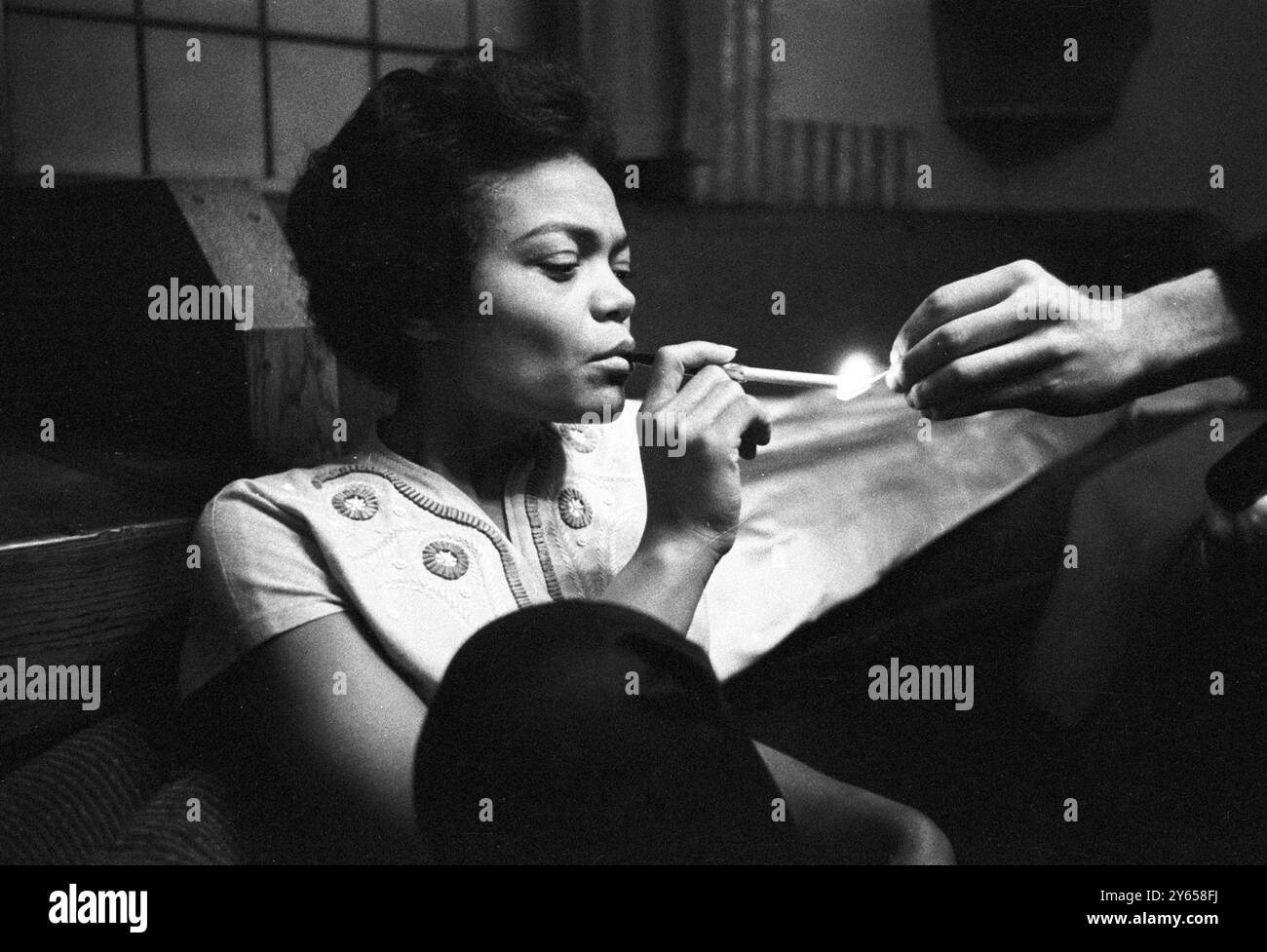 La cantante, attrice e cabarettista americana Eartha Kitt accende una sigaretta. È a Londra a fare un film. 13 gennaio 1957 Foto Stock