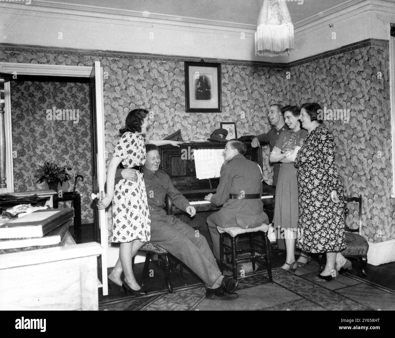 Cantate il canto intorno al pianoforte a casa a Erith, Kent, anni '1940 Foto Stock