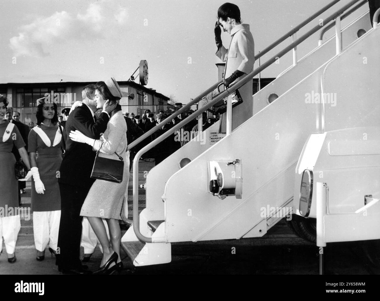 La First Lady americana , la signora Jacqueline Kennedy , moglie del presidente , abbraccia il cognato il principe Radziwill , che a sua volta dà un bacio alla sorella di sua moglie dopo che si è dimessa dal Boeing Airliner in cui lei e la principessa Lee Radziwill erano volati da Karachi dopo il loro viaggio in India e Pakistan . La signora Kennedy è arrivata per una visita privata di tre giorni a Londra durante la quale pranzerà con la regina Elisabetta . 26 marzo 1962 Foto Stock