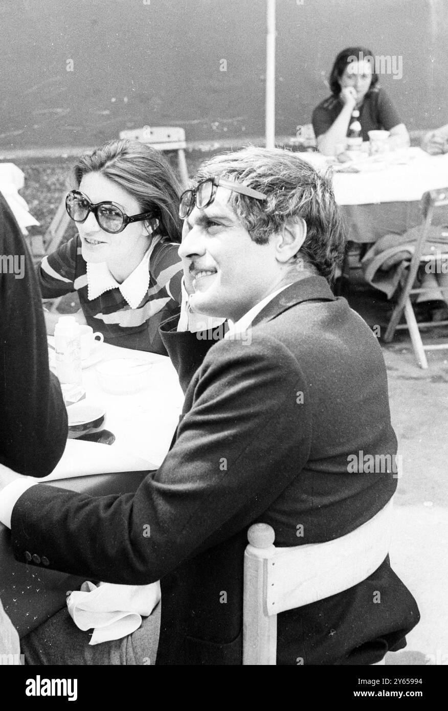 Omar Sharif riposa gli occhiali sulla fronte mentre si rilassa in un ristorante romano . Il suo compagno è l'attrice francese Anouk Aimee . Entrambi stanno lavorando nel film l'appuntamento in cui Anouk interpreta una modella e Omar un avvocato italiano 7 maggio 1968 Foto Stock