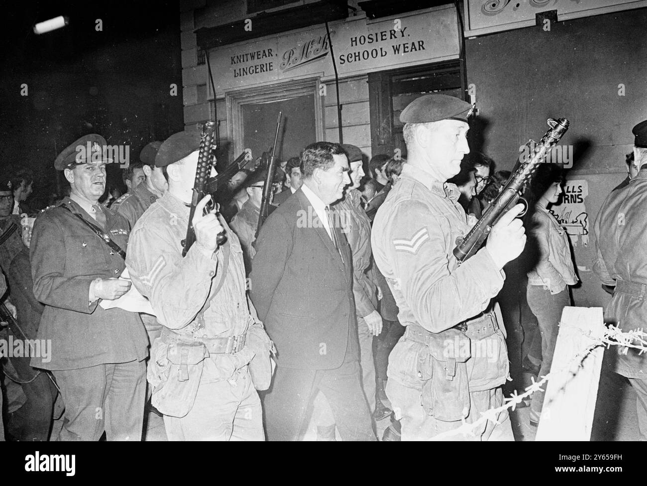 Il ministro della difesa Denis Healey è scortato da soldati britannici che tirano fuori le armi mentre visitava la zona di Catholic Falls Road durante la sua visita a Belfast per vedere di persona come le forze britanniche stanno assicurando l'area ora che le barricate stanno scendendo. Durante il tour fu accompagnato dal generale Sir Ian Freeland, G.O.C., irlanda del Nord, 18 settembre 1969 Foto Stock