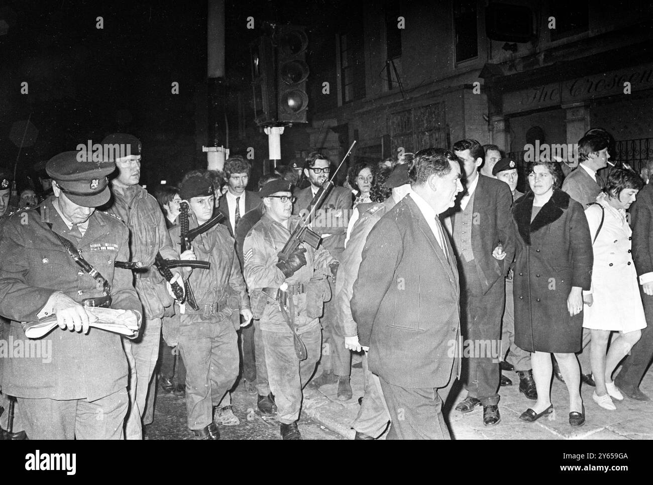Denis Healey , ministro della difesa britannico, è scortato da soldati britannici che tirano le armi da fuoco mentre visitava la zona di Catholic Falls Road durante la sua visita a Belfast per vedere di persona come le forze britanniche stanno assicurando la zona ora che le barricate stanno scendendo . Era accompagnato dal generale di lieut Sir Ian Freeland , GoRPC , Irlanda del Nord . 18 settembre 1969 Foto Stock