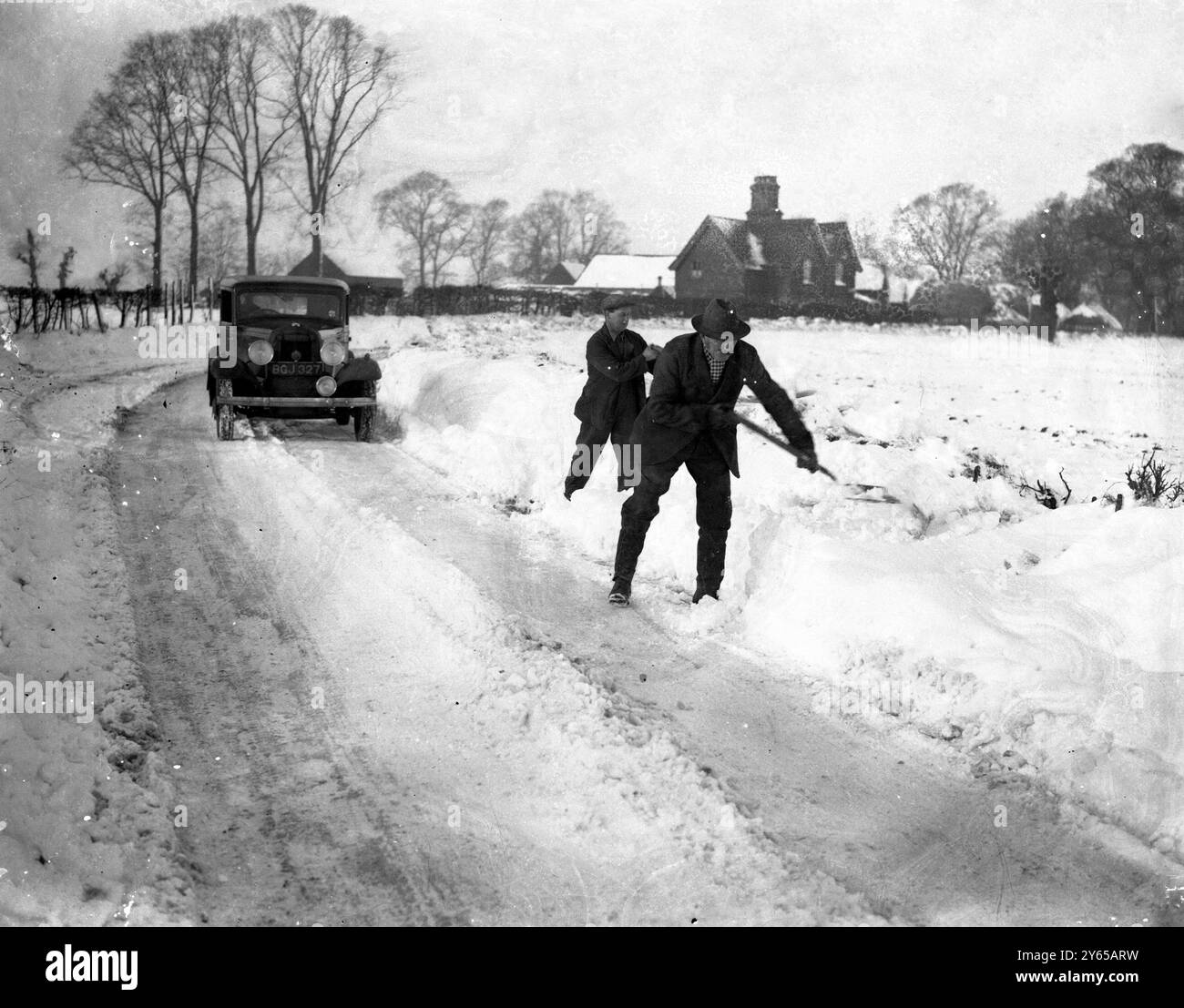 I furti di neve rallentano il traffico nell'Hertfordshire. I piedi di Snowdrifts in profondità interferiscono con il traffico sulla strada Ware-Bishops Stortford vicino all'Hertfordshire . Bande di operai stanno ripulendo la neve dalla parte superiore. Fotografie ; sgombrare la strada della neve tra Ware e Bishop 's Stortford . 27 gennaio 1937 Foto Stock