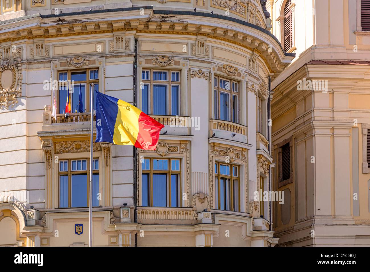 Bandiera rumena di fronte all'edificio che ospita il comune di Sibiu, Sibiu, Transilvania, Romania Foto Stock
