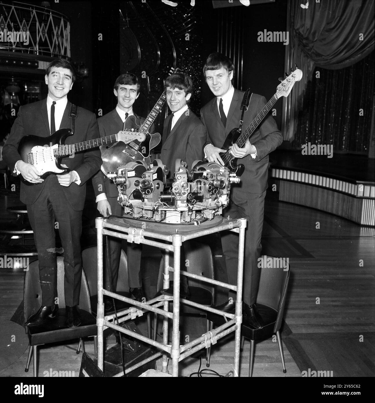 Sedici cineprese si concentrano sul gruppo di Liverpool The Swinging Blue Jeans mentre sono ritratti nella Empire Ballroom , Leicester Square , Londra durante le riprese di un film del gruppo in circlorama . I ragazzi sono (da sinistra a destra) Ralph Ellis , chitarra e voce , Ray Ennis , chitarra e voce , Norman Kulhke , batteria e voce amd Les Braid , basso e voce . Il loro album di successo Hippy Hippy Shake sta rapidamente montando le classifiche pop . 11 gennaio 1964 Foto Stock