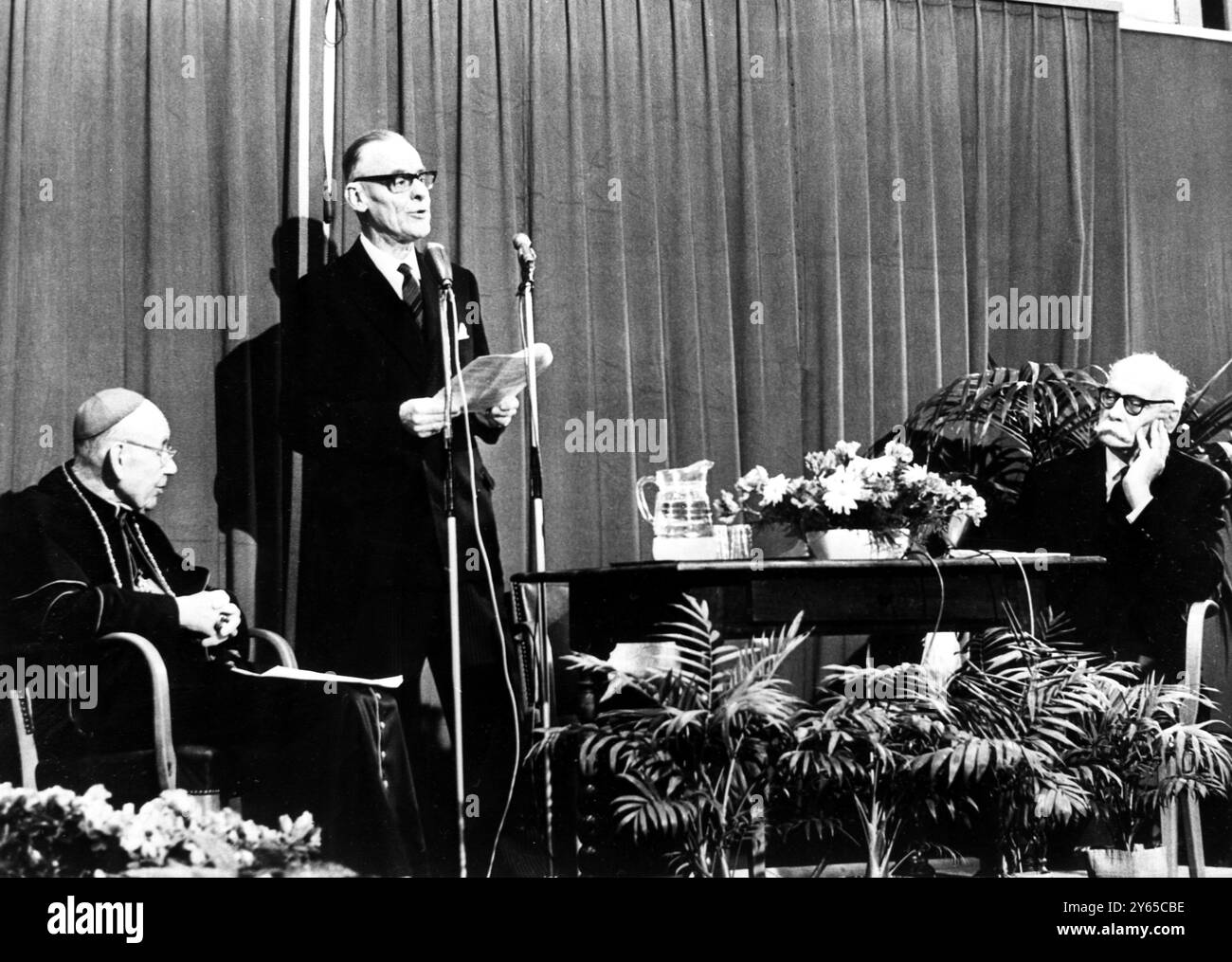 Vissert van Hooft , Segretario generale del Consiglio Mondiale delle Chiese , si rivolge ai delegati nella storica riunione del Consiglio di Ginevra . Nel corso della riunione è stato raggiunto un accordo volto a spianare la strada all' unità dei cristiani e a porre fine alle differenze tra cattolici e protestanti . A sinistra si trova il Cardinale Bea , capo della Segreteria Vaticana per la promozione dell' unità dei cristiani , e a destra , il Pastore francese Marc Boegner . 20 febbraio 1965 Foto Stock