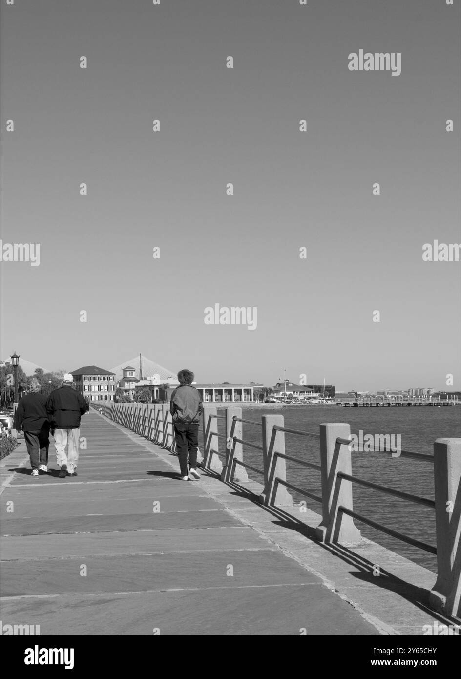 Una donna caucasica di età compresa tra 55 e 60 anni che cammina lungo la passeggiata panoramica del Battery di Charleston, South Carolina, USA, Foto Stock