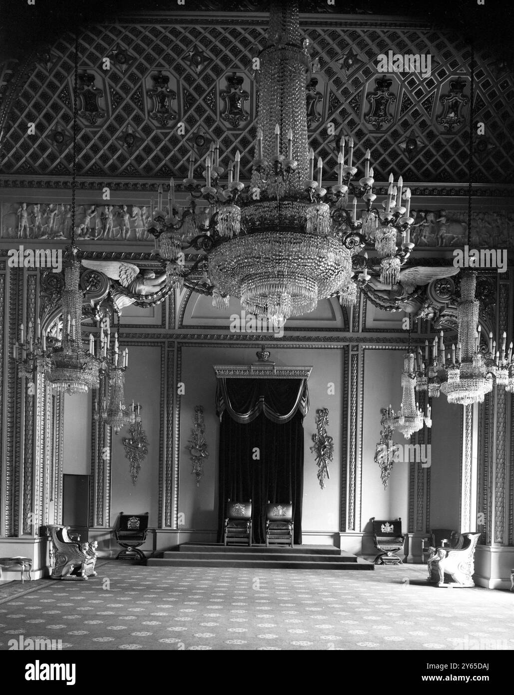 All'interno di Buckingham Palace, la sala del Trono, lunga oltre 60 piedi, utilizzata per gli investimenti statali e per l'accoglienza delle delegazioni. Il Trono Dias a tre livelli sotto un'imponente tettoia di velluto rosso e oro è visto all'estremità opposta. I sette bellissimi lampadari , suspercede dal soffitto insieme danno una luce pari a quasi 3000 candele . Un tappeto rosso scuro di Bruxelles copre il pavimento e un elaborato freize , raffigurante la Guerra delle due rose, corre intorno alle pareti Foto Stock